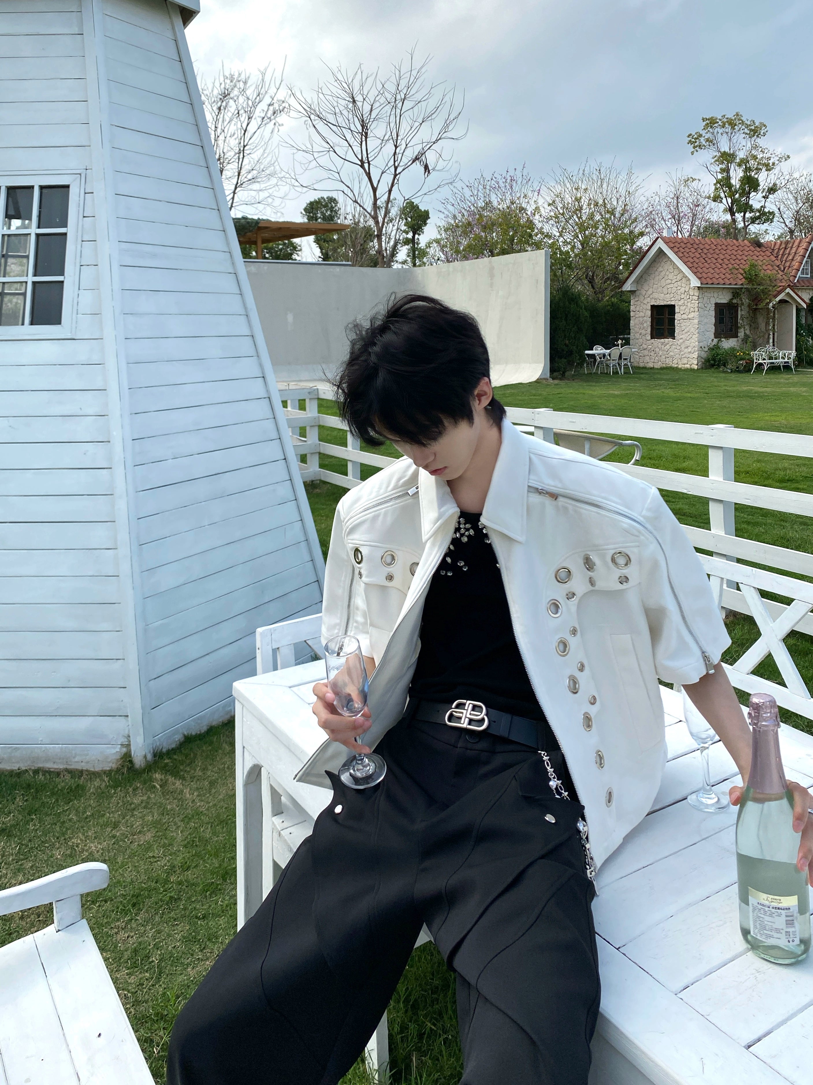 This avant-garde cropped jacket by Sanhoostudio showcases futuristic hollow-metal inspired cutouts with bold shoulder pads. Its oversized silhouette, lightweight material, and modern edge make it a standout layering piece for streetwear fans who embrace unique design and cutting-edge style.