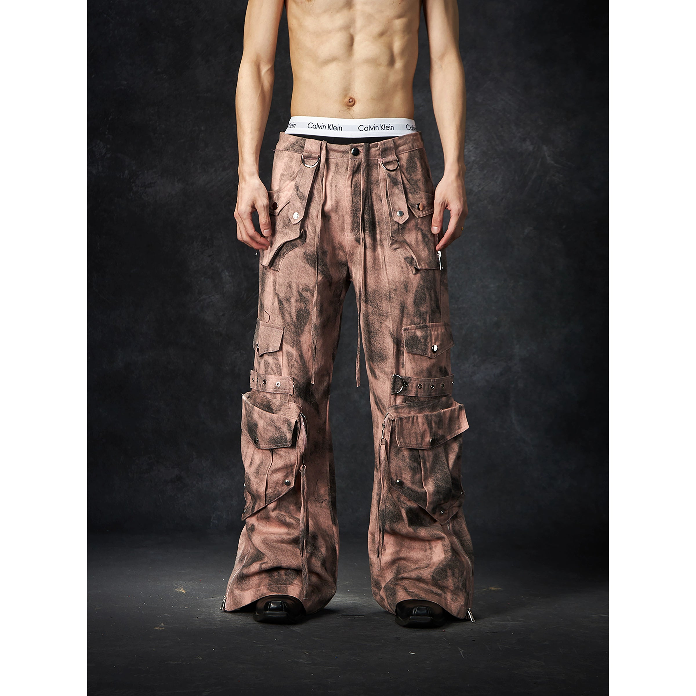 The Sanhoostudio distressed mud-dye cargo pants feature a heavy washed finish, rugged multi-pocket design, and a relaxed straight-leg fit. Perfect for utilitarian and high street styling, they combine functionality with bold design, making them an essential statement for everyday streetwear wardrobes.