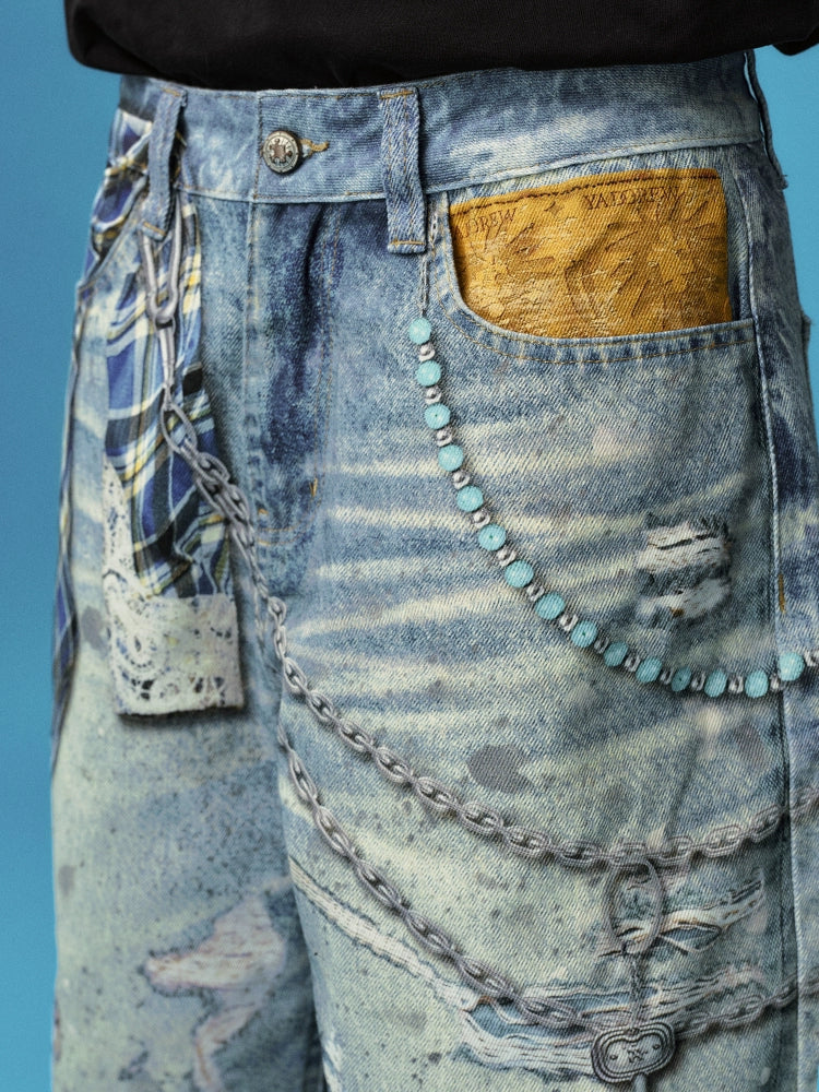 These Sanhoostudio denim shorts feature plaid-inspired patterns with chain print accents, merging casual denim with bold graphic expression. With a relaxed oversized fit, they’re ideal for layering into creative high street looks.