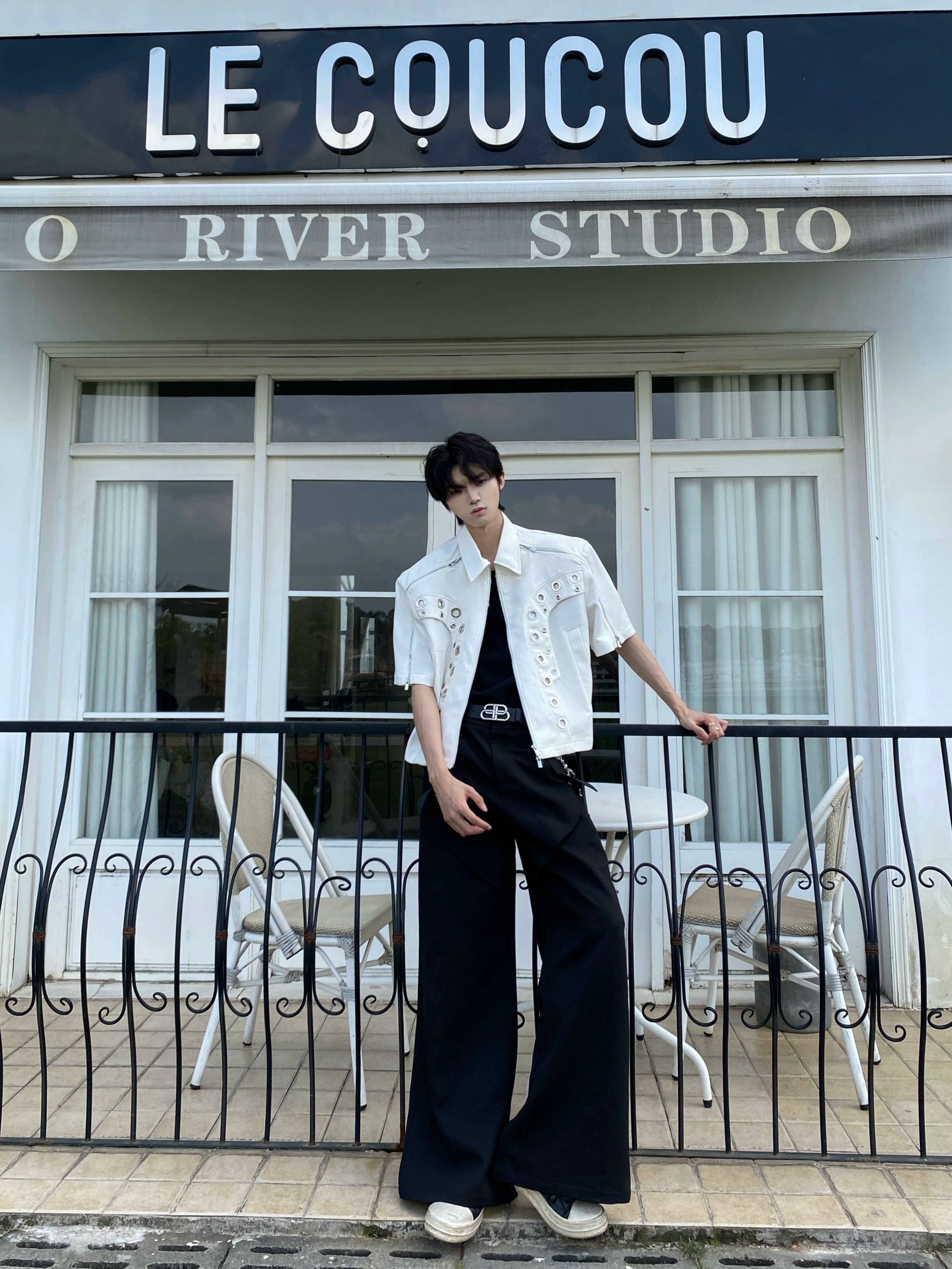 This avant-garde cropped jacket by Sanhoostudio showcases futuristic hollow-metal inspired cutouts with bold shoulder pads. Its oversized silhouette, lightweight material, and modern edge make it a standout layering piece for streetwear fans who embrace unique design and cutting-edge style.