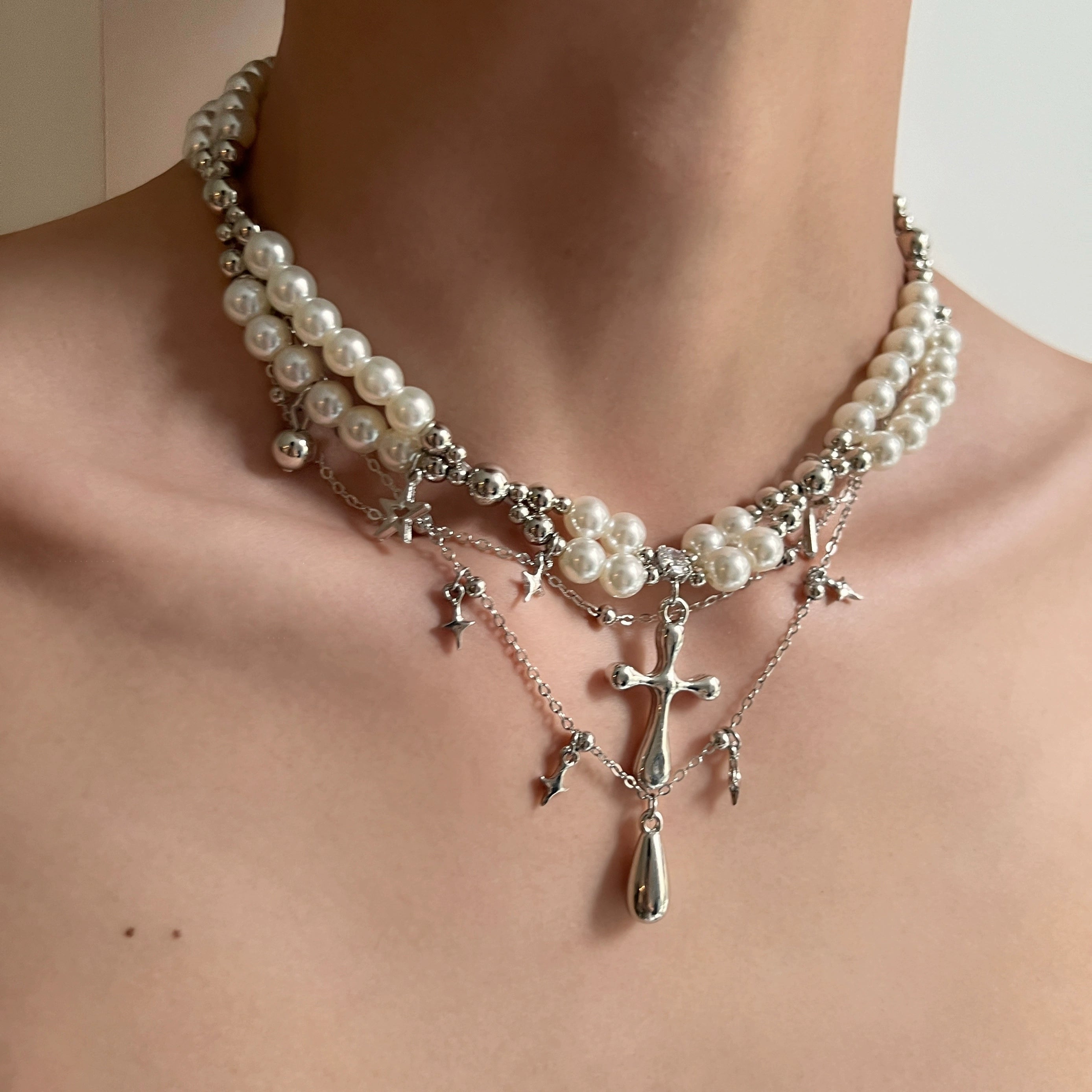 Sanhoostudio’s cross pearl multi-layer necklace blends pearls with gothic cross details to create a luxury streetwear statement—perfect for layered styling and evening looks.