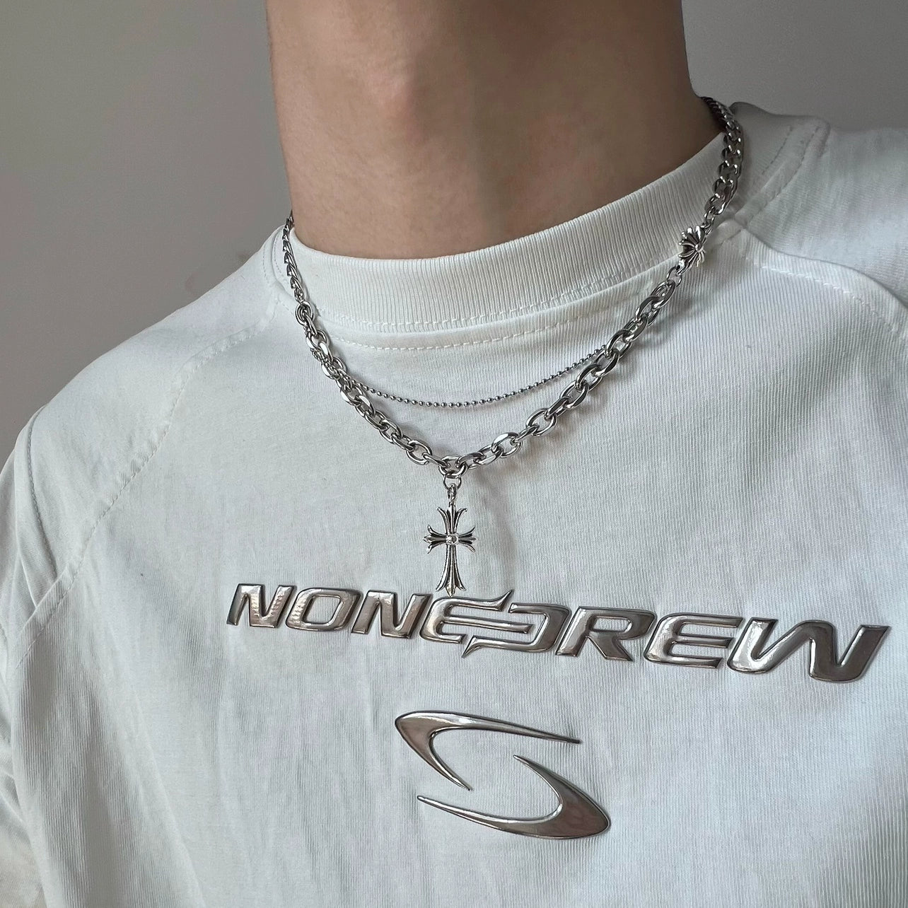 Discover Sanhoostudio’s cross double-layer titanium necklace—sturdy titanium construction paired with layered chains for a versatile unisex accessory suitable for casual and dressy street looks.