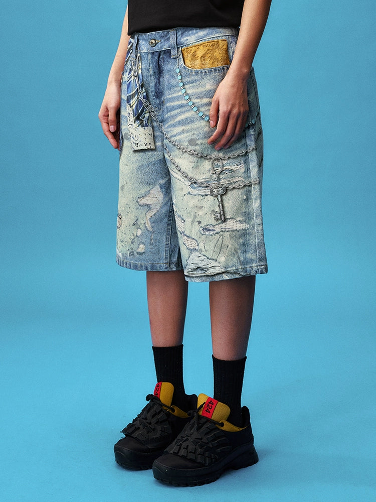 These Sanhoostudio denim shorts feature plaid-inspired patterns with chain print accents, merging casual denim with bold graphic expression. With a relaxed oversized fit, they’re ideal for layering into creative high street looks.