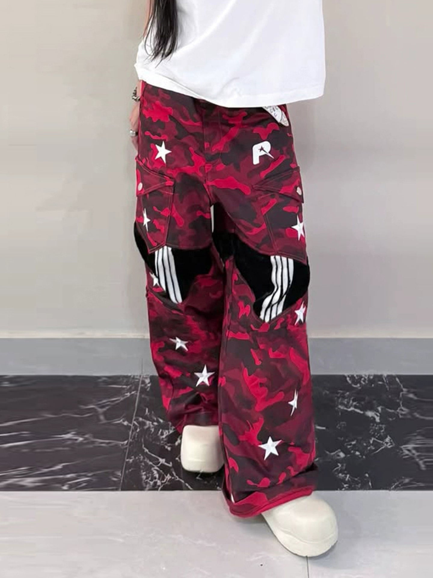 These Sanhoostudio camouflage pants feature bold star prints, patchwork design, and a low-waist loose fit. With their retro streetwear inspiration, they merge military ruggedness with casual style, making them a versatile staple for high street fashion.
