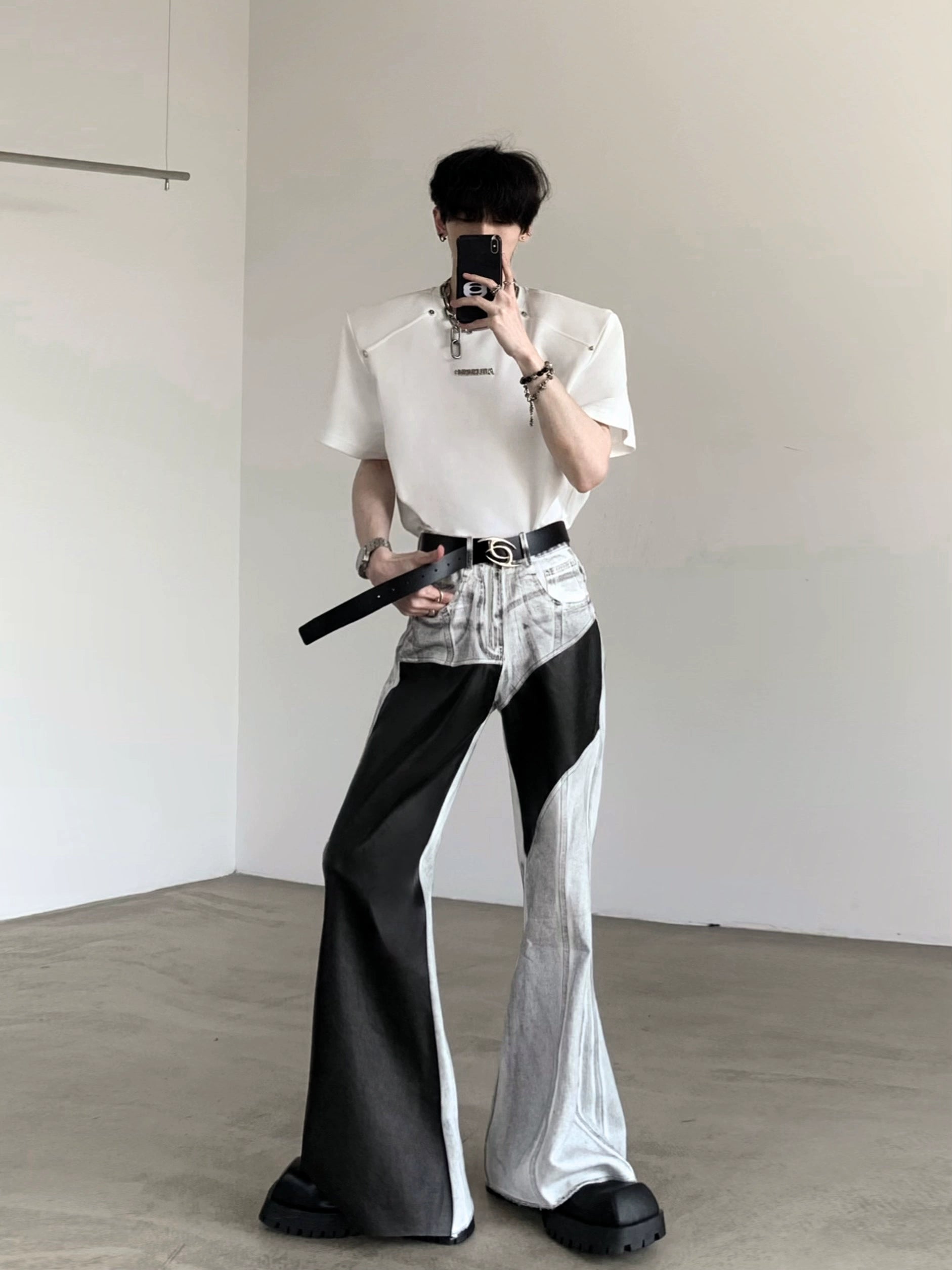The Sanhoostudio distressed off-white jeans combine premium leather patchwork with a subtle flared cut. Their faded finish adds a rugged vintage vibe, while the unique detailing enhances versatility, making them a must-have for bold, high-fashion urban wardrobes.