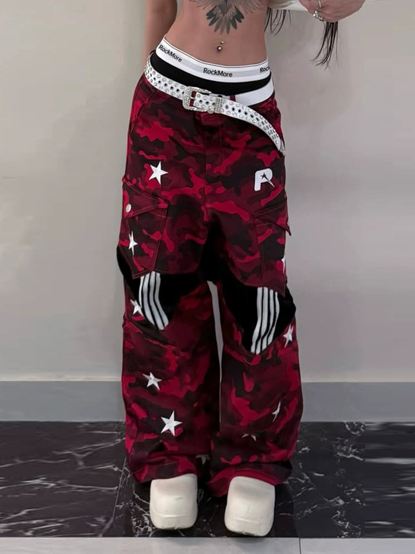 These Sanhoostudio camouflage pants feature bold star prints, patchwork design, and a low-waist loose fit. With their retro streetwear inspiration, they merge military ruggedness with casual style, making them a versatile staple for high street fashion.