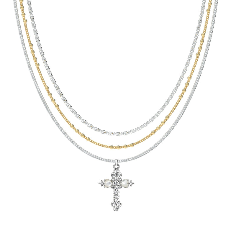 Embrace soft elegance with Sanhoostudio’s layered petal cross necklace. Adorned with mother-of-pearl accents, it brings timeless charm and modern refinement to your style.