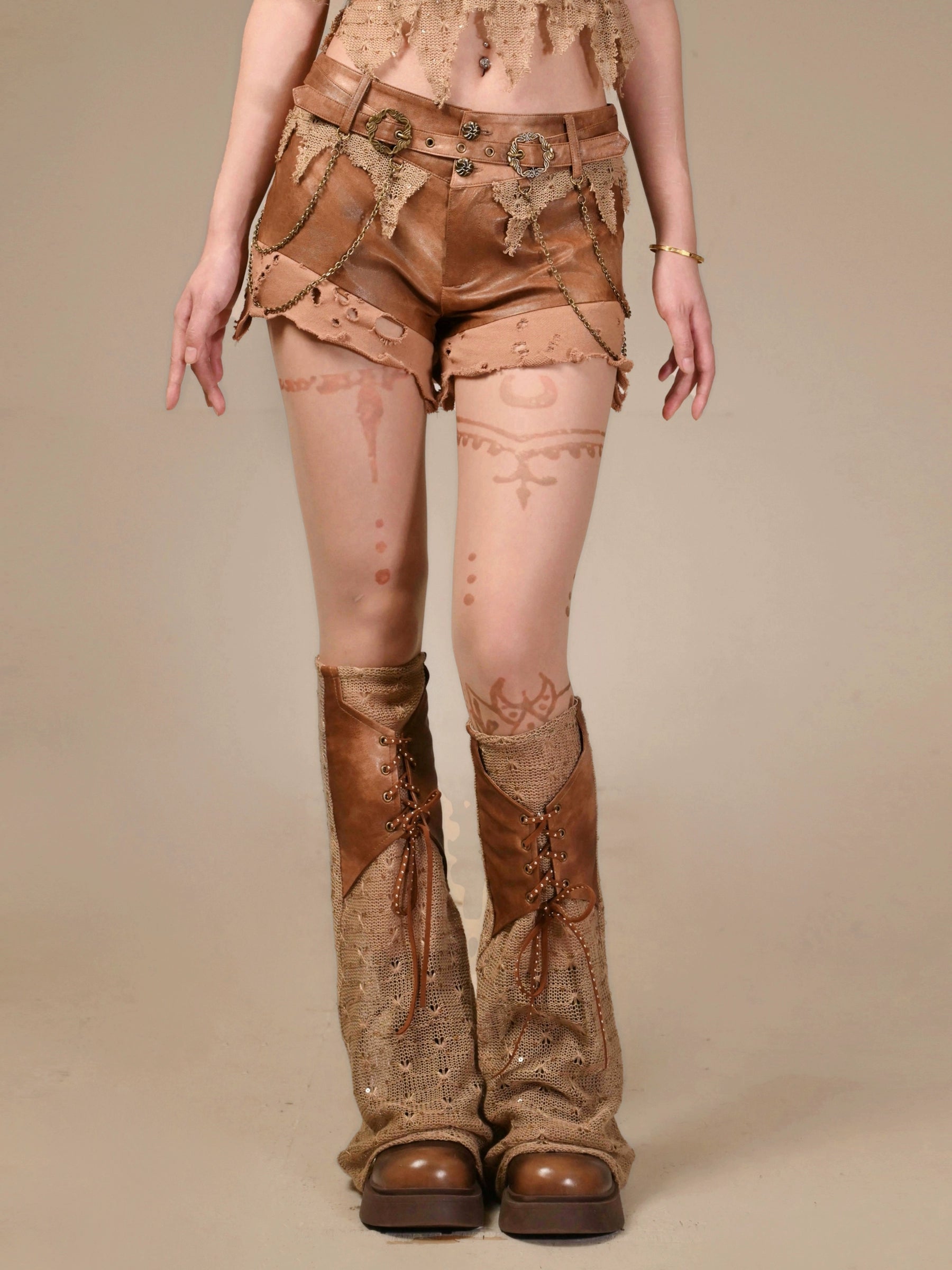Sanhoostudio’s distressed PU leather low-waist shorts feature Y2K rebellion with rugged cut-outs and punk edge, perfect for bold summer styling.