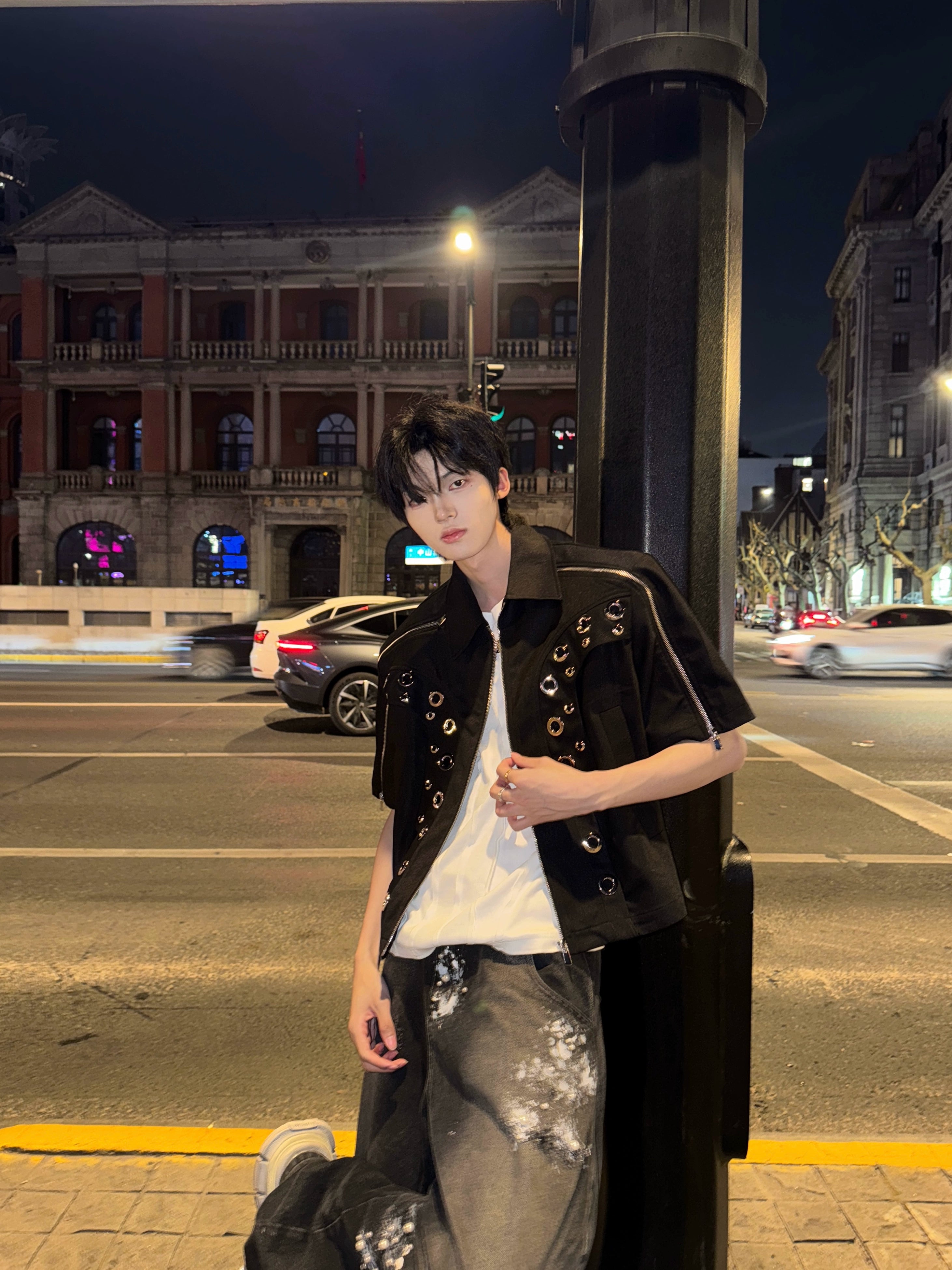 This avant-garde cropped jacket by Sanhoostudio showcases futuristic hollow-metal inspired cutouts with bold shoulder pads. Its oversized silhouette, lightweight material, and modern edge make it a standout layering piece for streetwear fans who embrace unique design and cutting-edge style.