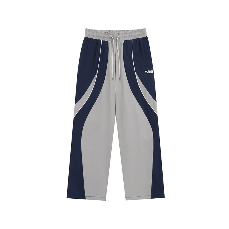 These vintage-inspired lightweight sport pants from Sanhoostudio feature a water-resistant finish and relaxed fit. Perfect for casual outings or streetwear looks with a retro athletic twist.