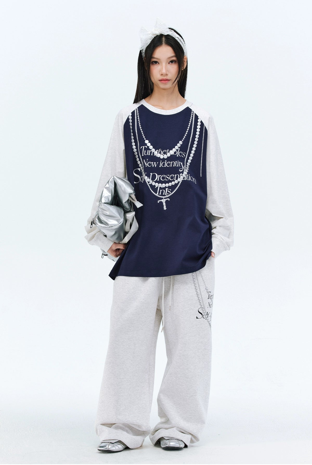 These Sanhoostudio pants stand out with pearl chain embellishments and bold slogan prints, merging casual comfort with high street individuality. Designed with a relaxed fit, they highlight a balance of playful accessories and edgy fashion vibes.