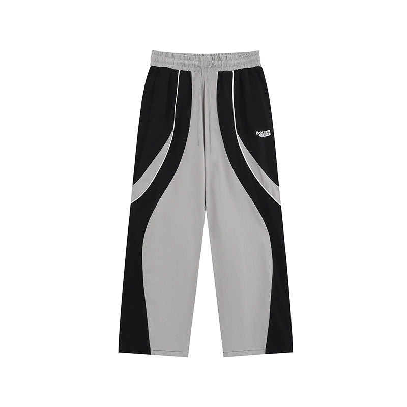 These vintage-inspired lightweight sport pants from Sanhoostudio feature a water-resistant finish and relaxed fit. Perfect for casual outings or streetwear looks with a retro athletic twist.