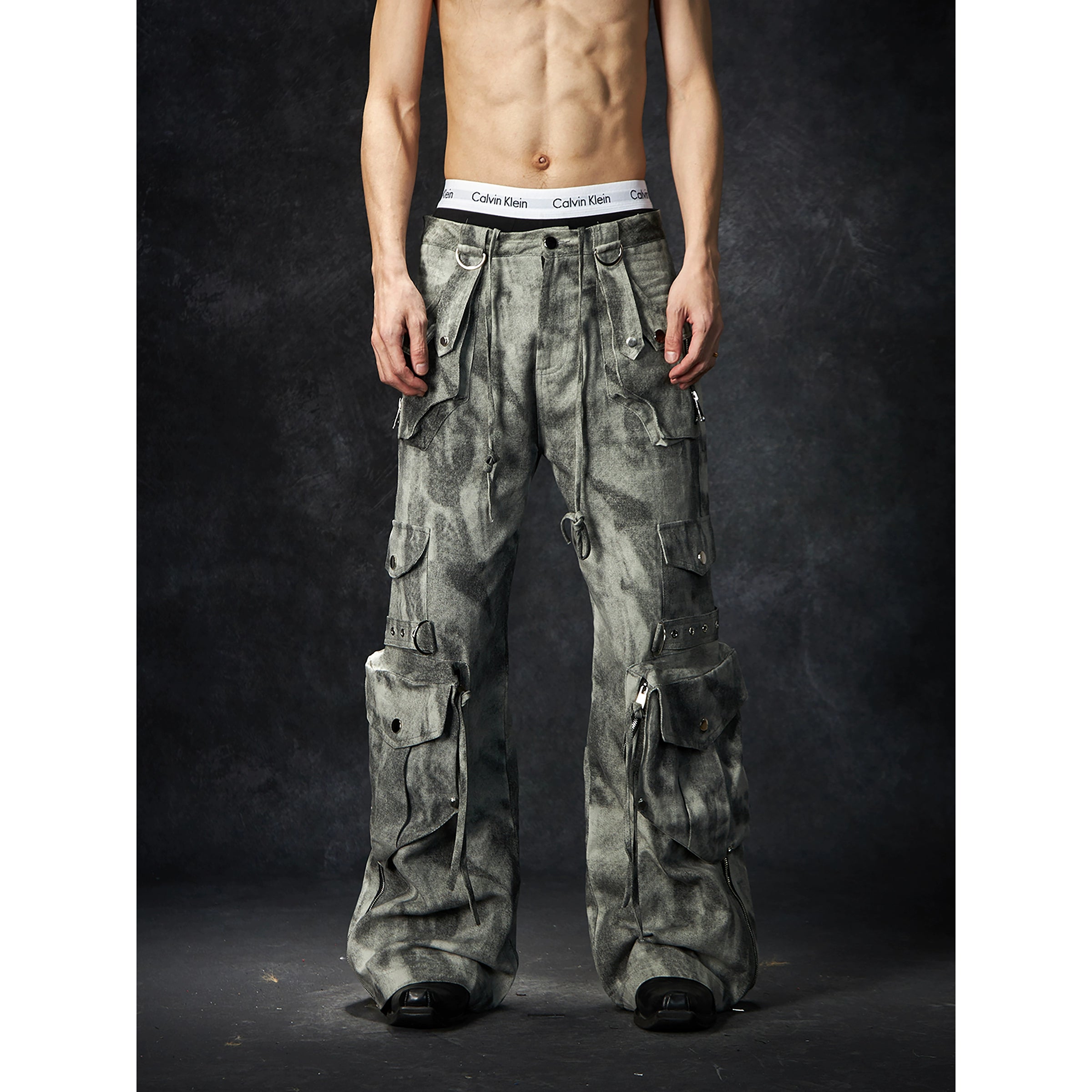 The Sanhoostudio distressed mud-dye cargo pants feature a heavy washed finish, rugged multi-pocket design, and a relaxed straight-leg fit. Perfect for utilitarian and high street styling, they combine functionality with bold design, making them an essential statement for everyday streetwear wardrobes.