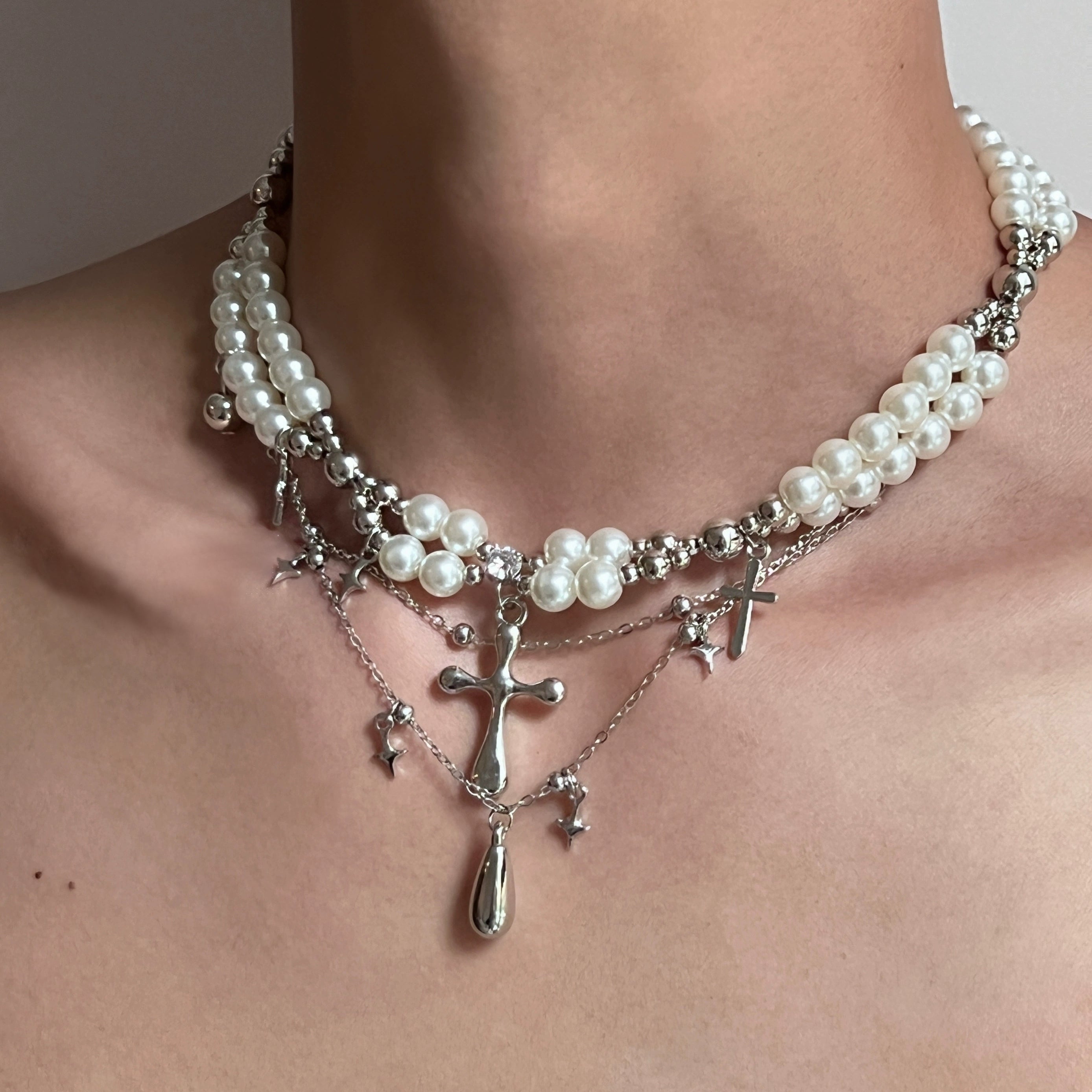Sanhoostudio’s cross pearl multi-layer necklace blends pearls with gothic cross details to create a luxury streetwear statement—perfect for layered styling and evening looks.