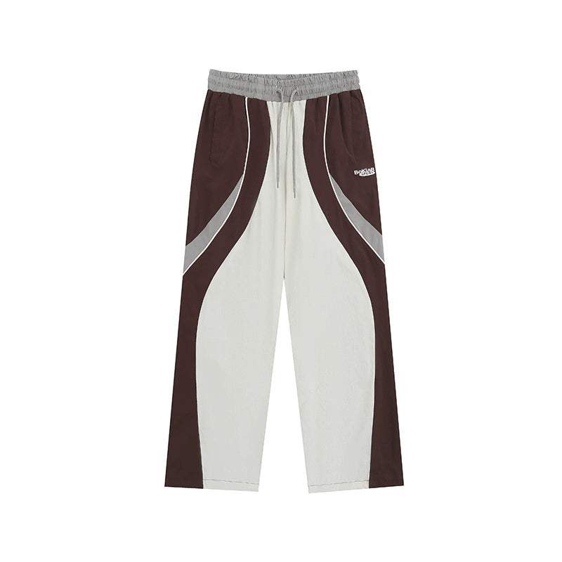 These vintage-inspired lightweight sport pants from Sanhoostudio feature a water-resistant finish and relaxed fit. Perfect for casual outings or streetwear looks with a retro athletic twist.