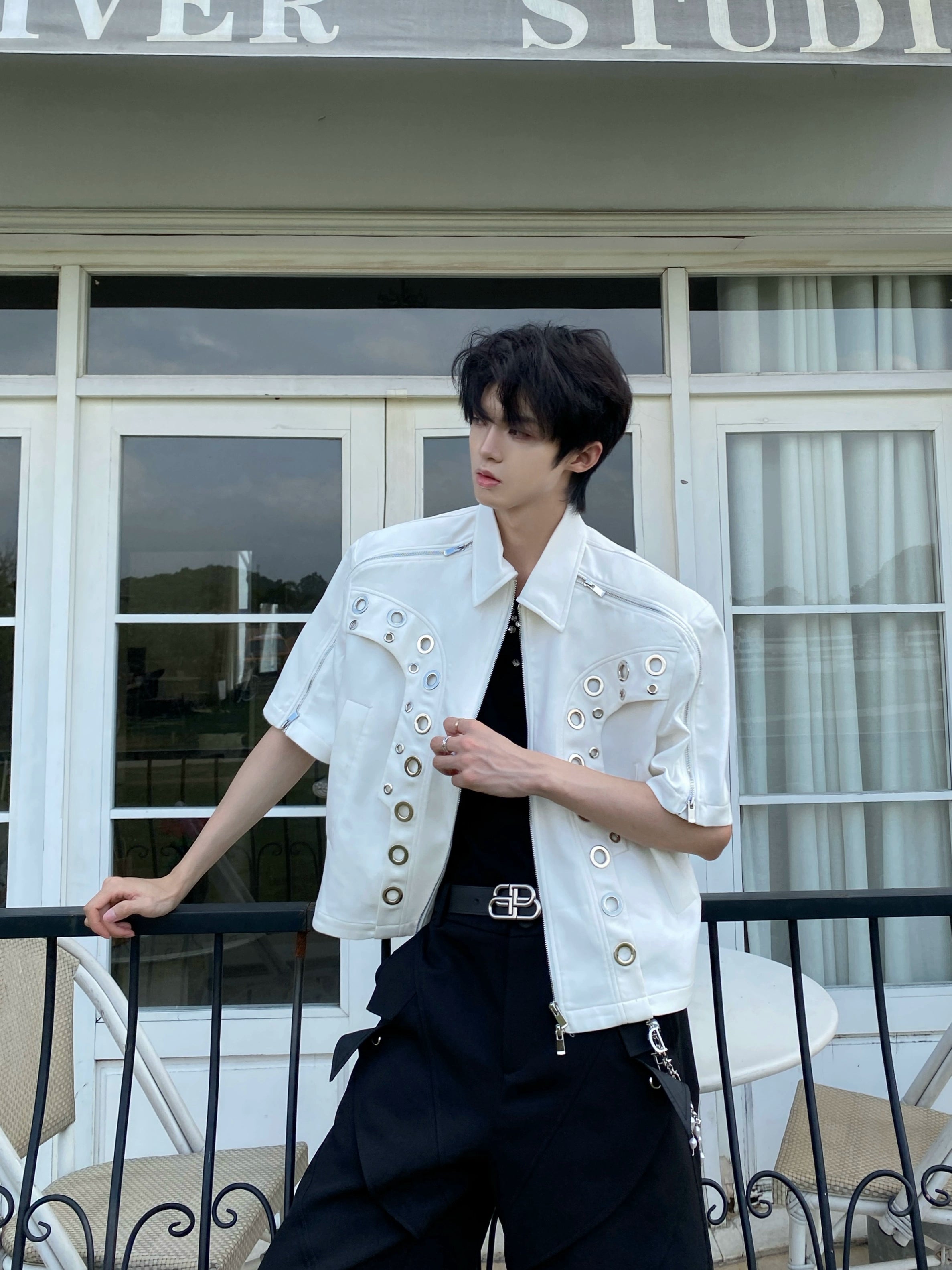 This avant-garde cropped jacket by Sanhoostudio showcases futuristic hollow-metal inspired cutouts with bold shoulder pads. Its oversized silhouette, lightweight material, and modern edge make it a standout layering piece for streetwear fans who embrace unique design and cutting-edge style.