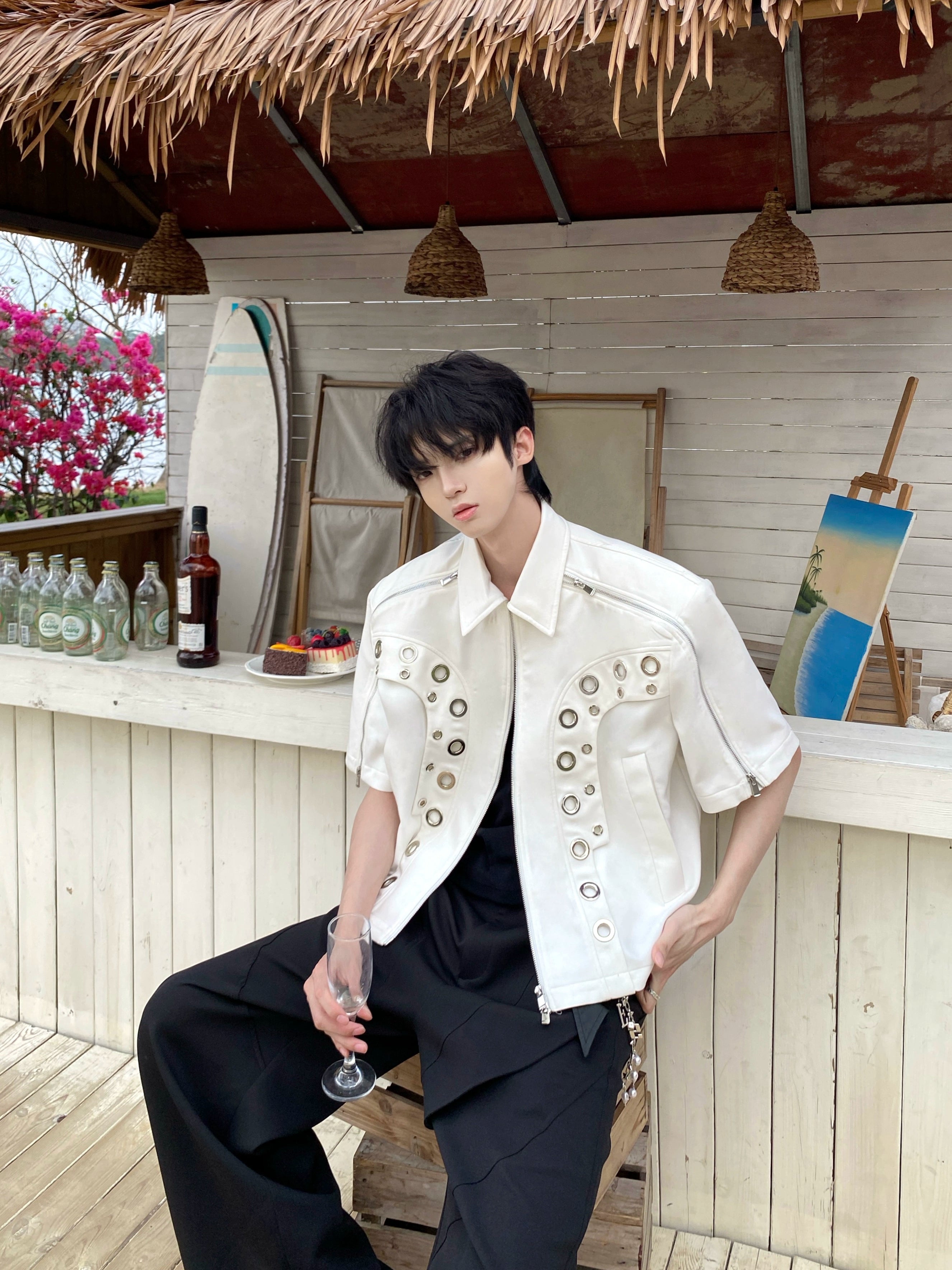 This avant-garde cropped jacket by Sanhoostudio showcases futuristic hollow-metal inspired cutouts with bold shoulder pads. Its oversized silhouette, lightweight material, and modern edge make it a standout layering piece for streetwear fans who embrace unique design and cutting-edge style.