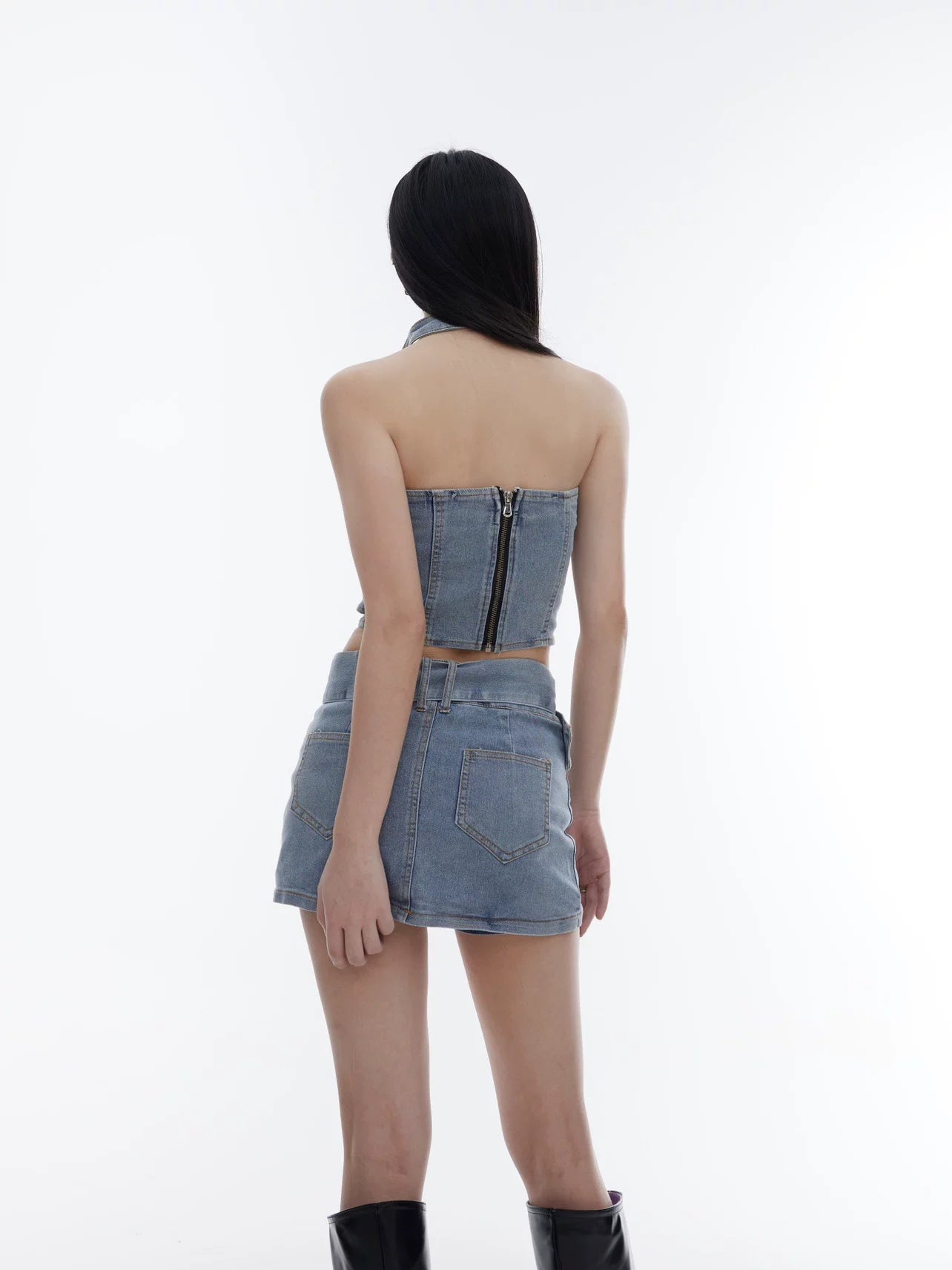 Sanhoostudio denim two-piece set featuring a halter crop top and body-hugging skirt. Designed for a bold and slimming streetwear look.