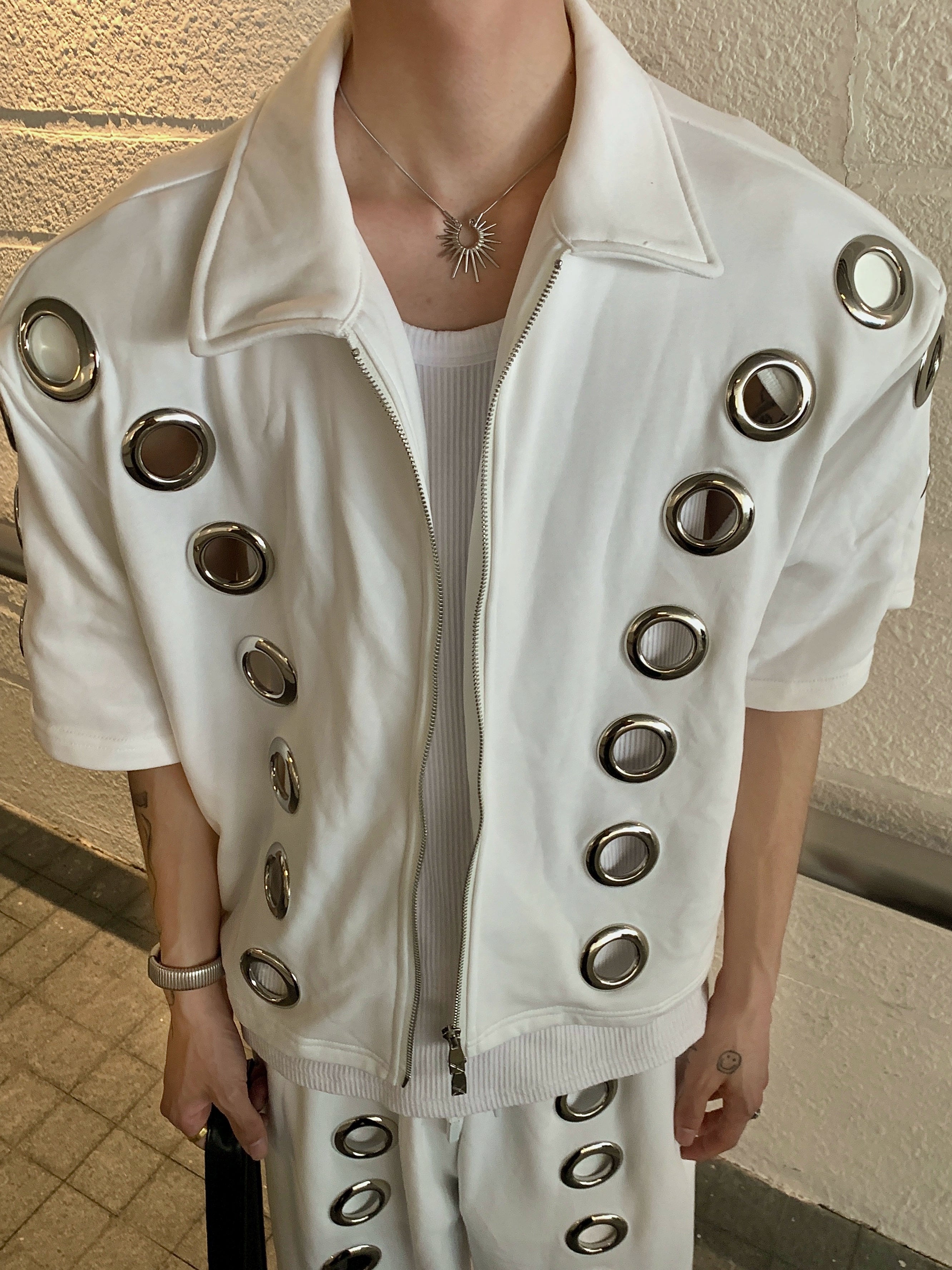 The Sanhoostudio two-piece set combines a cropped hoodie with metal ring hollow details and a matching bottom for a coordinated high street look. With its relaxed fit and edgy design, this set delivers both comfort and standout individuality for streetwear enthusiasts.