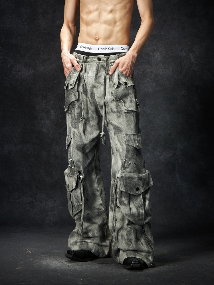 The Sanhoostudio distressed mud-dye cargo pants feature a heavy washed finish, rugged multi-pocket design, and a relaxed straight-leg fit. Perfect for utilitarian and high street styling, they combine functionality with bold design, making them an essential statement for everyday streetwear wardrobes.