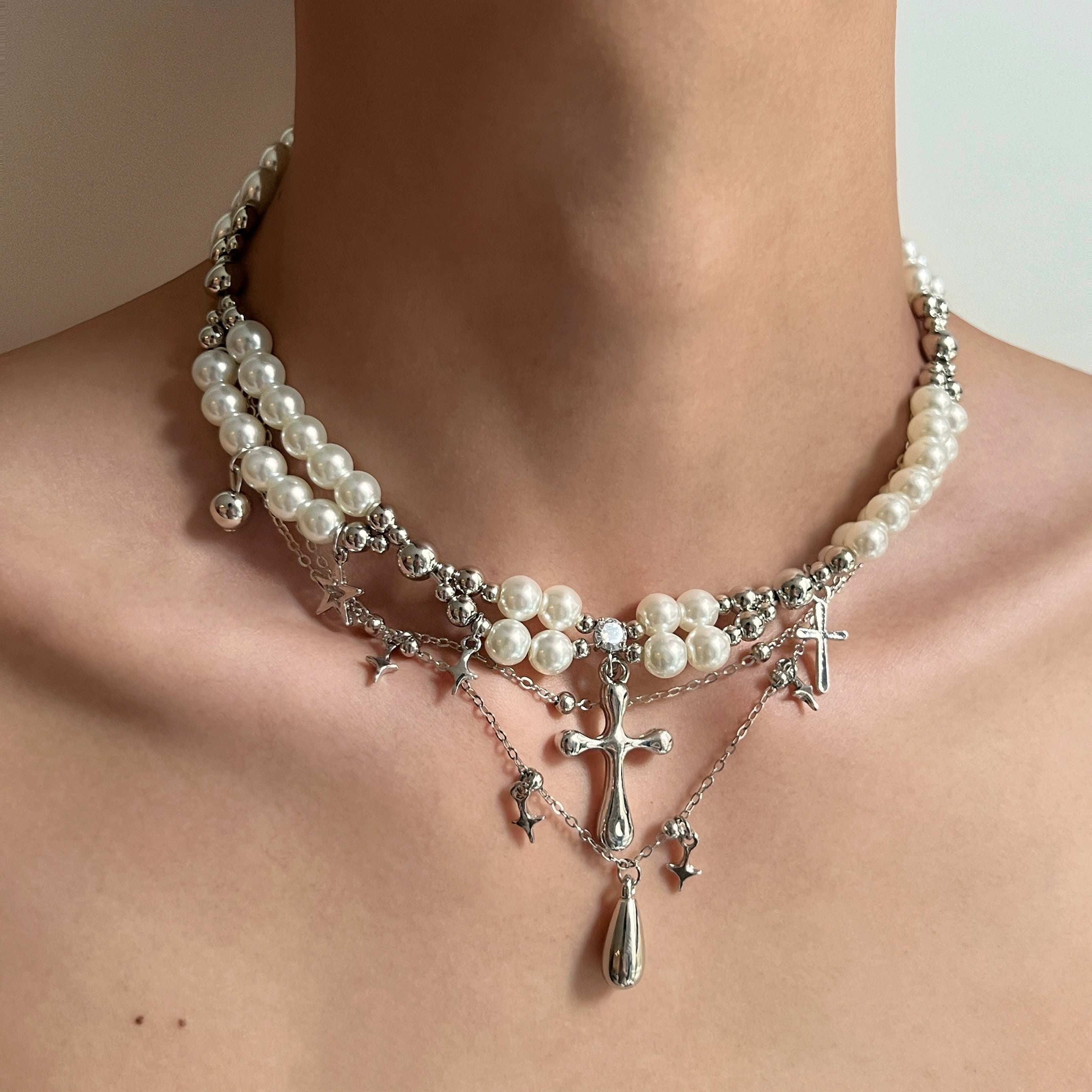Sanhoostudio’s cross pearl multi-layer necklace blends pearls with gothic cross details to create a luxury streetwear statement—perfect for layered styling and evening looks.