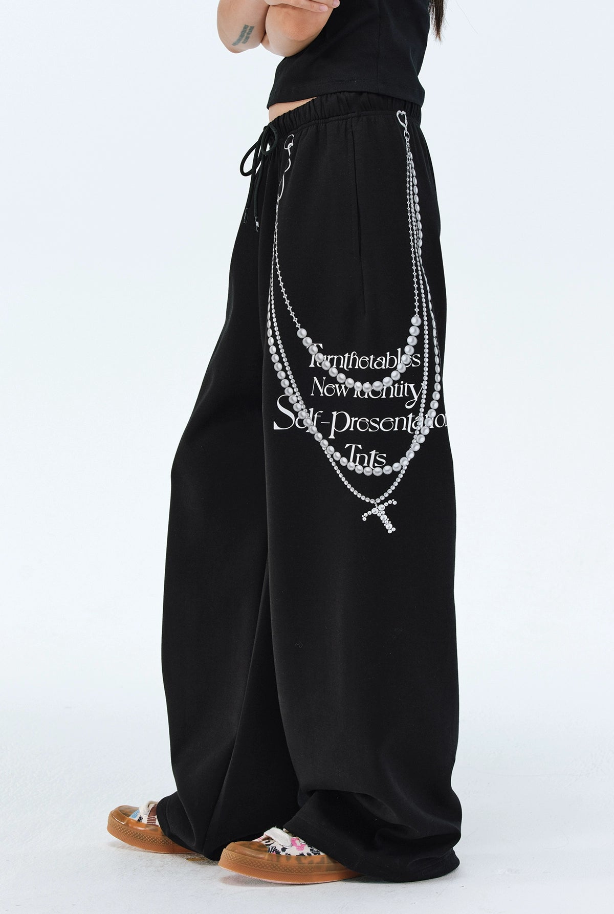 These Sanhoostudio pants stand out with pearl chain embellishments and bold slogan prints, merging casual comfort with high street individuality. Designed with a relaxed fit, they highlight a balance of playful accessories and edgy fashion vibes.