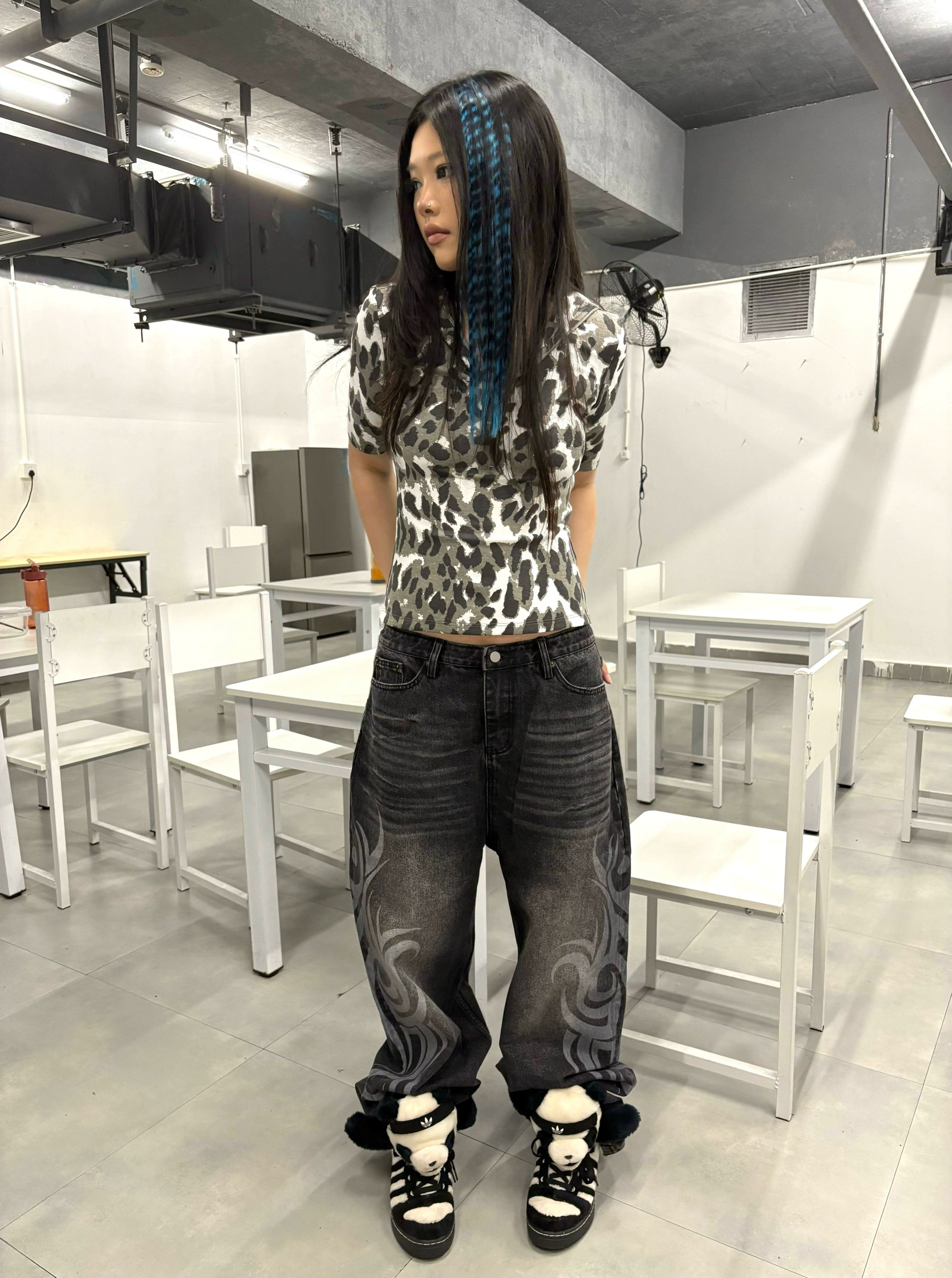 These Sanhoostudio jeans showcase bold totem rune prints across a wide-leg straight cut. The oversized fit and retro wash add cultural inspiration to streetwear, making them a unique fashion-forward piece.