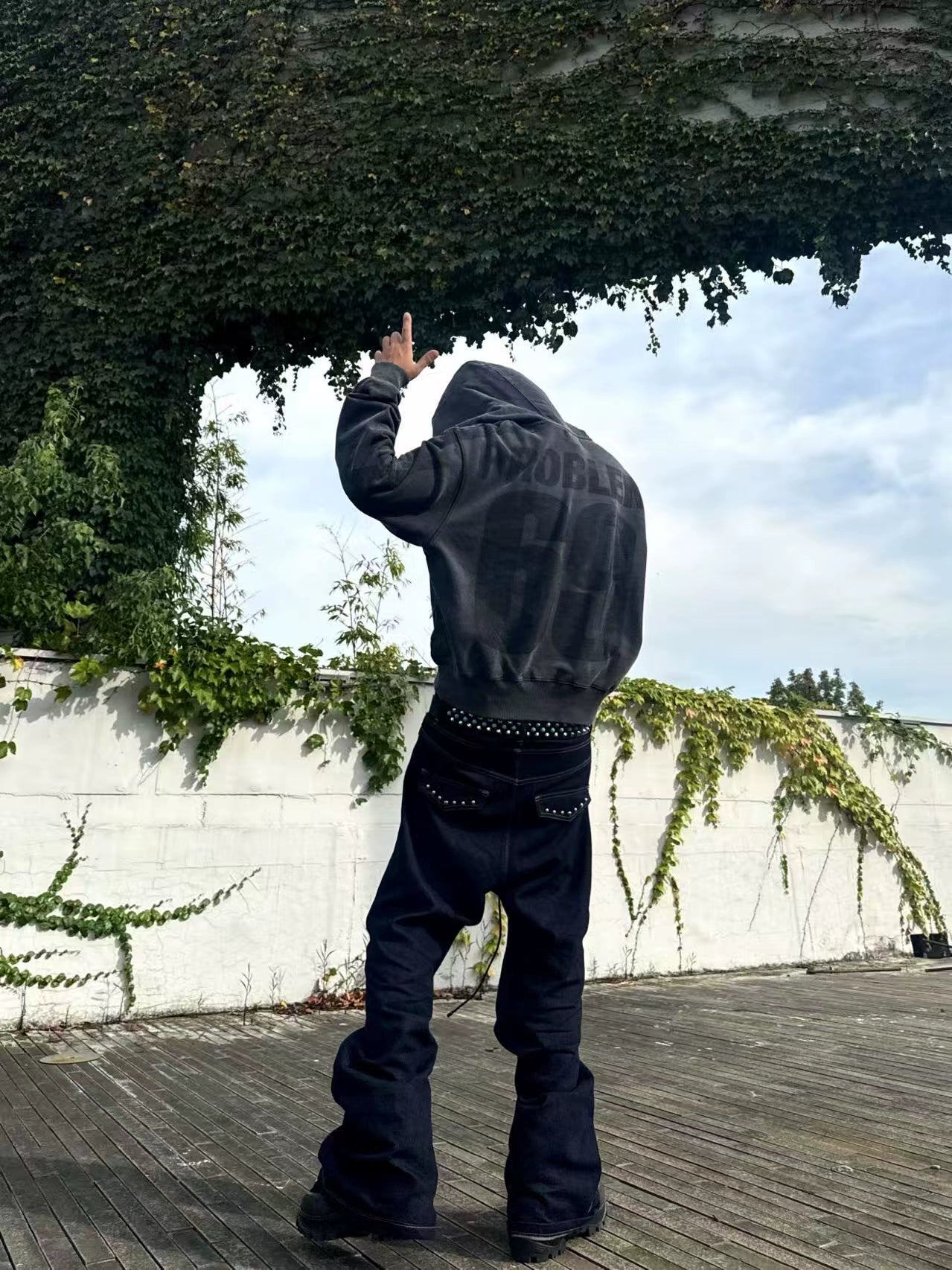 The Sanhoostudio double-waist jeans showcase a unique studded drawstring design with blade-cut legs. Their deconstructed silhouette and washed finish bring punk-inspired energy to everyday streetwear styling, making them a bold wardrobe choice.