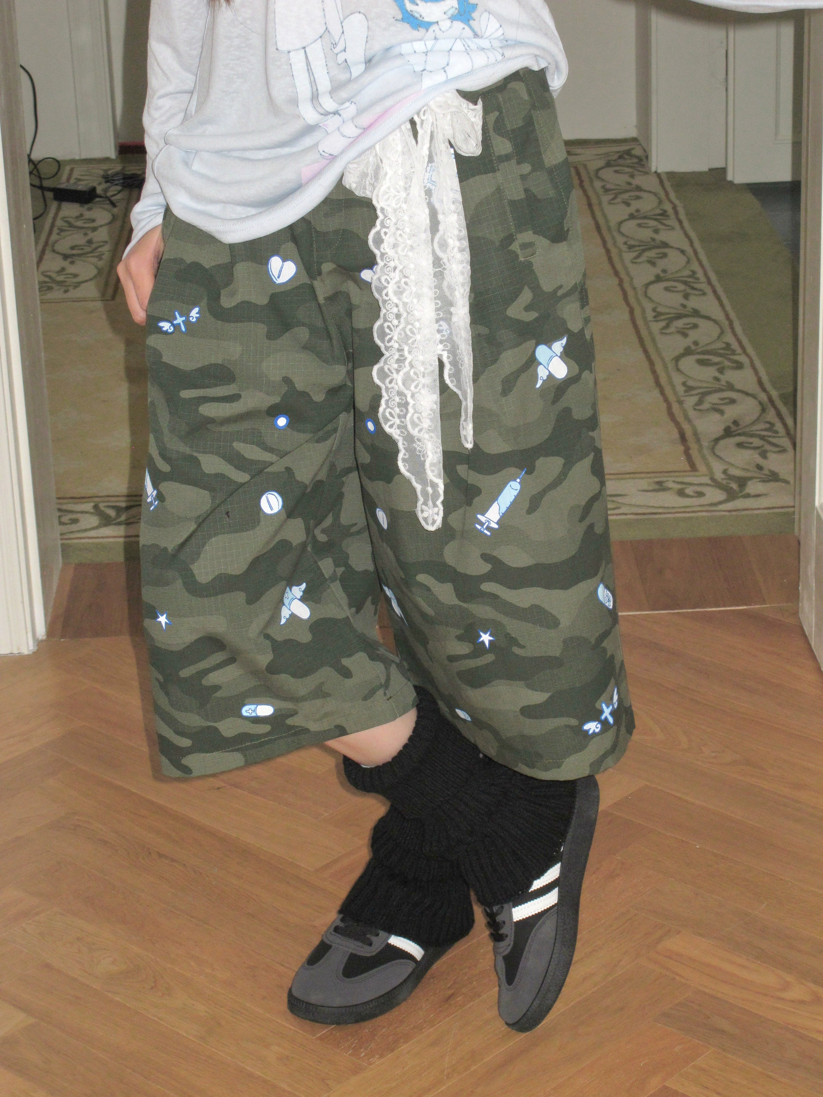 These camouflage print cropped pants from Sanhoostudio bring a relaxed streetwear touch with a loose straight-leg silhouette. Designed for comfort and versatility, they blend urban edge with casual style for everyday wear.