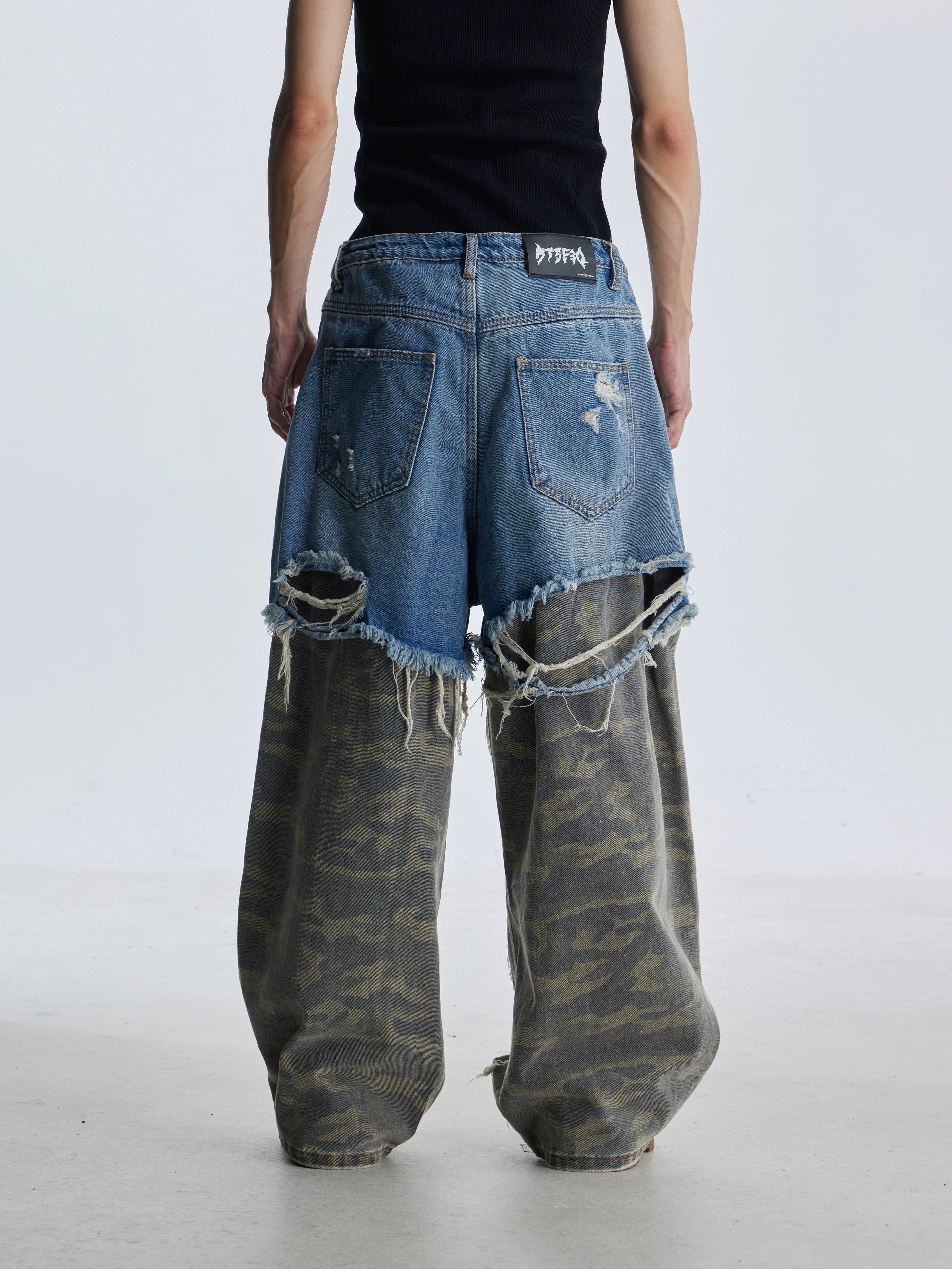 These deconstructed patchwork camo jeans from Sanhoostudio feature a unique layered fake two-piece effect, distressed ripped accents, and a loose straight-leg silhouette. Combining vintage inspiration with edgy high street aesthetics, they are perfect for streetwear lovers seeking comfort, individuality.