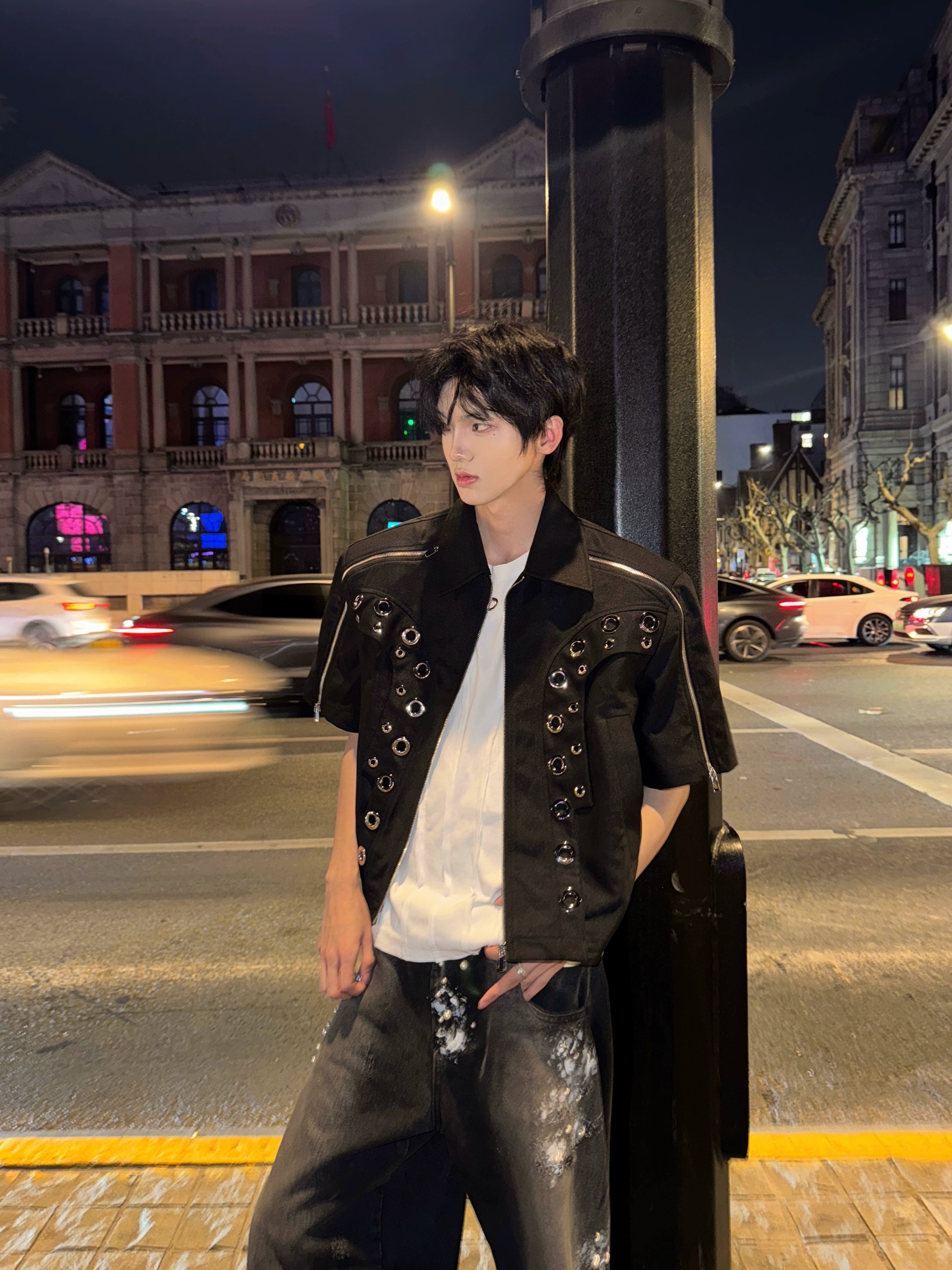 This avant-garde cropped jacket by Sanhoostudio showcases futuristic hollow-metal inspired cutouts with bold shoulder pads. Its oversized silhouette, lightweight material, and modern edge make it a standout layering piece for streetwear fans who embrace unique design and cutting-edge style.