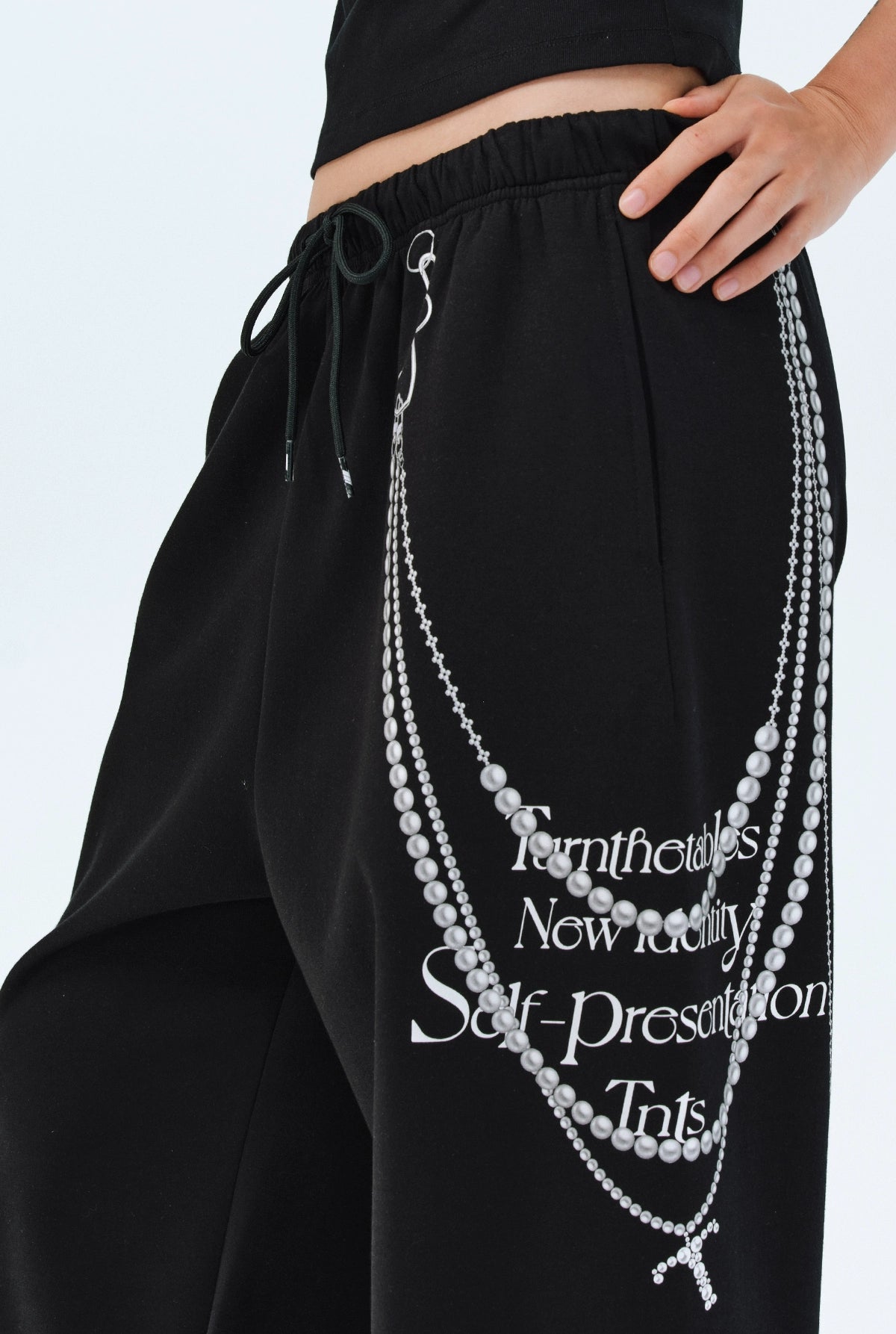 These Sanhoostudio pants stand out with pearl chain embellishments and bold slogan prints, merging casual comfort with high street individuality. Designed with a relaxed fit, they highlight a balance of playful accessories and edgy fashion vibes.