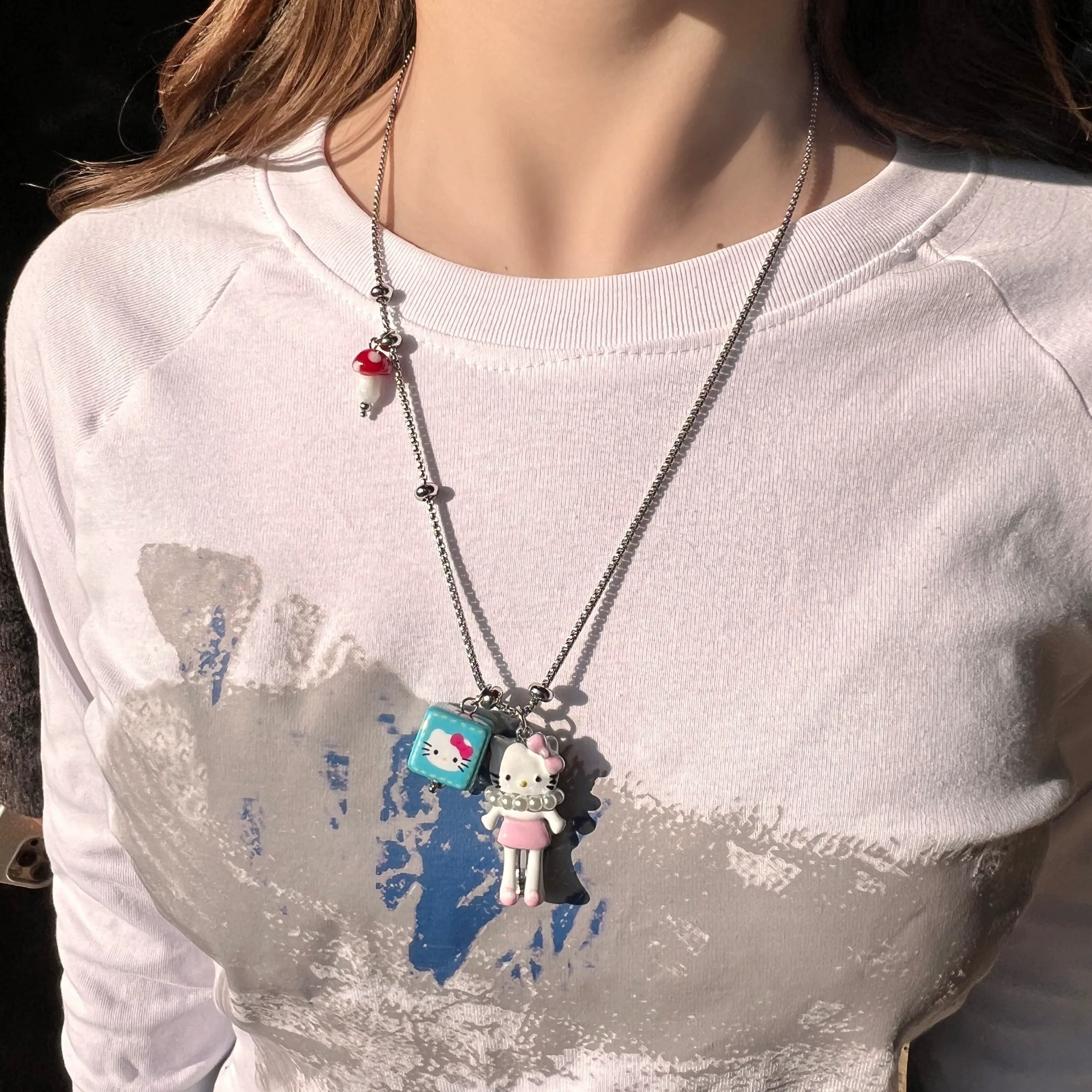 Sanhoostudio’s cute KT cat cartoon necklace adds a fun, youthful touch to any outfit. Designed for playful streetwear and kawaii-inspired fashion, it’s perfect for bold and quirky style statements.