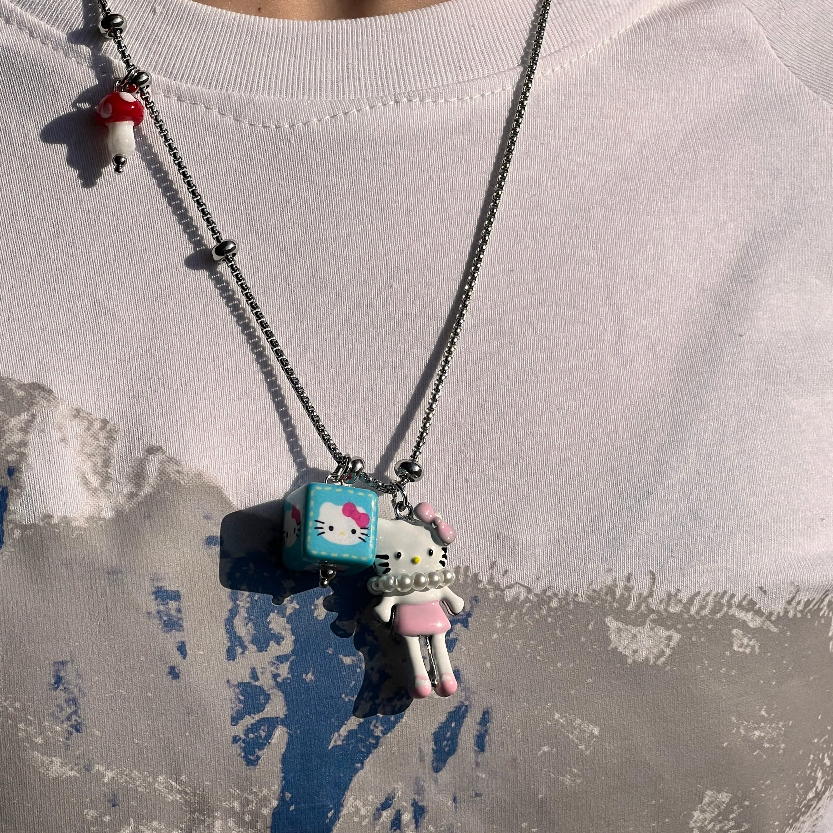 Sanhoostudio’s cute KT cat cartoon necklace adds a fun, youthful touch to any outfit. Designed for playful streetwear and kawaii-inspired fashion, it’s perfect for bold and quirky style statements.