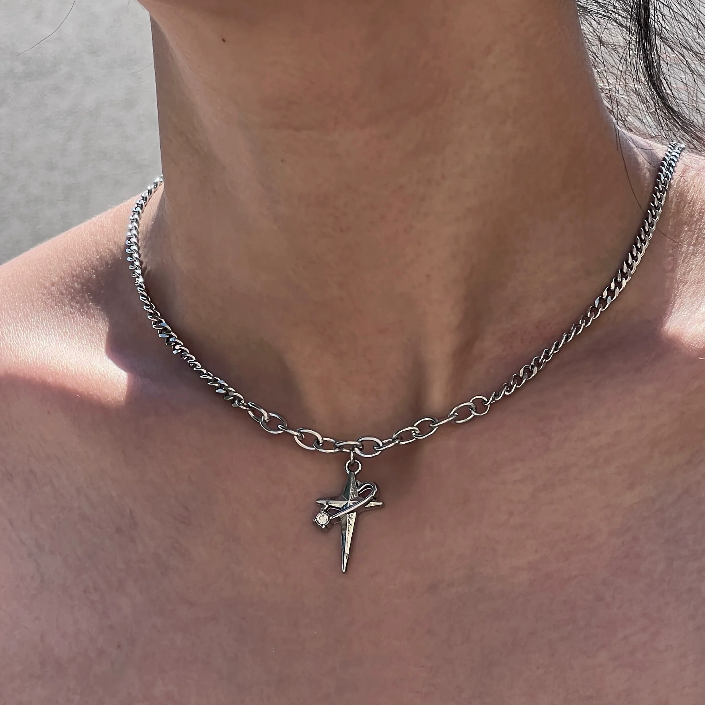 Sanhoostudio’s star cross wrap titanium necklace wraps gothic motifs into layered titanium design—sturdy, stylish, and ideal for dark-luxe streetwear and layered accessorizing.