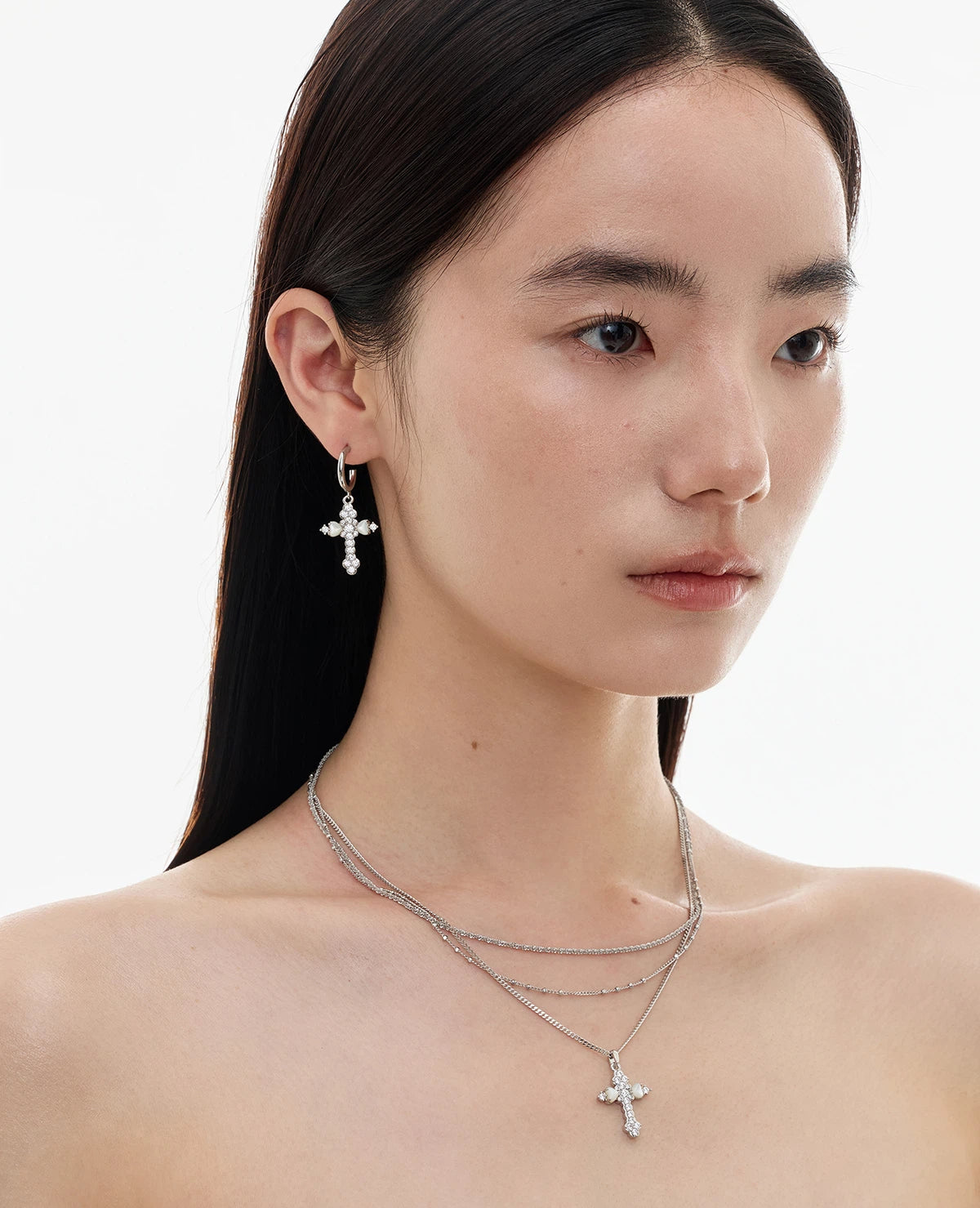 Embrace soft elegance with Sanhoostudio’s layered petal cross necklace. Adorned with mother-of-pearl accents, it brings timeless charm and modern refinement to your style.