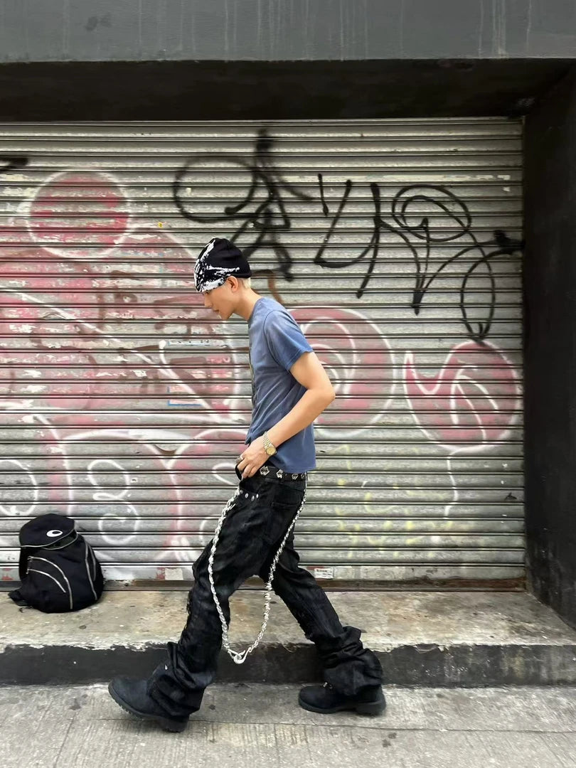 Sanhoostudio wax-finished denim pants made from breathable 100% cotton. Designed with curved cutting, distressed paneling, subtle stretch feel, and straight-leg silhouette for a bold dark street aesthetic.