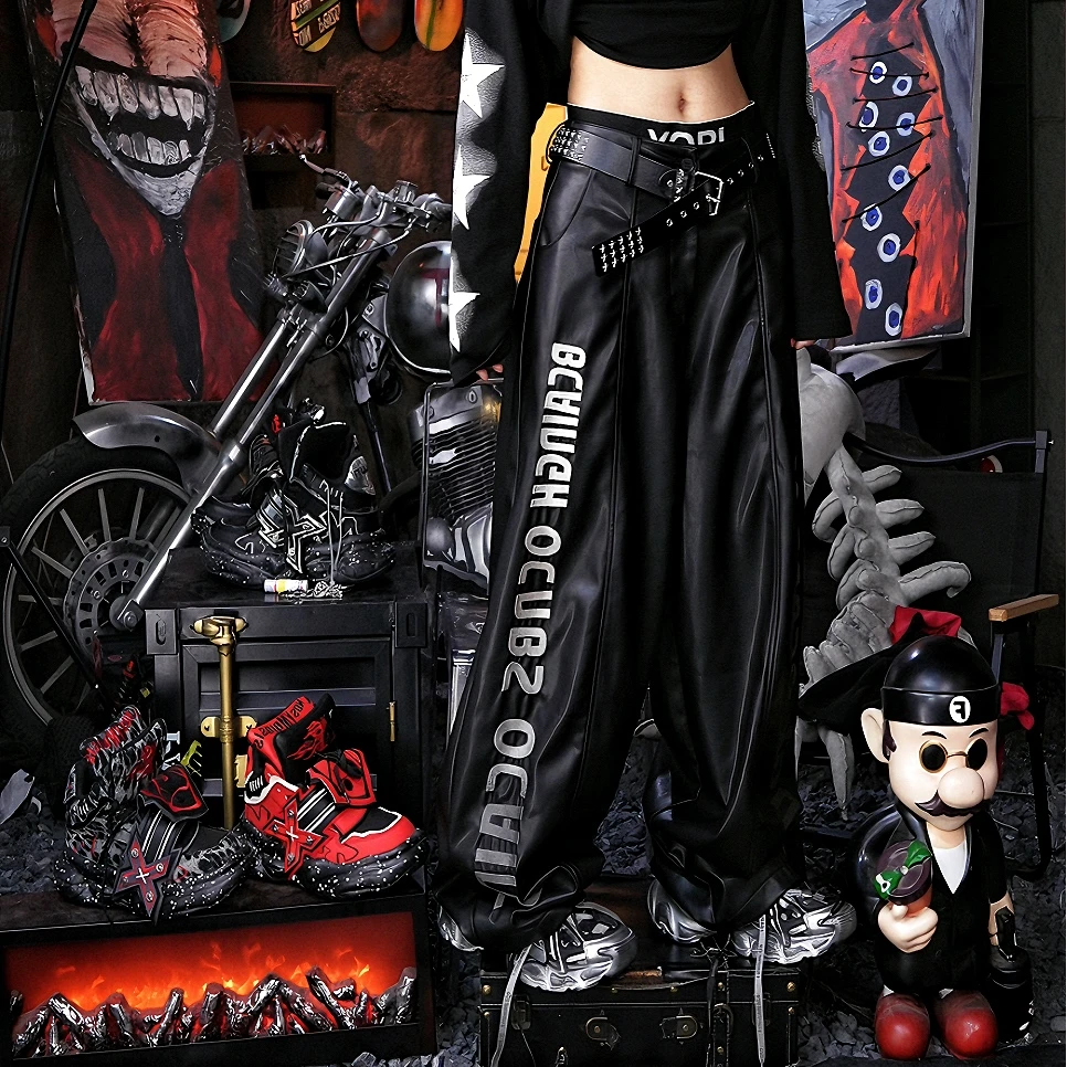 Sanhoostudio washed leather pants featuring gradient letter embroidery, distressed finish, and graffiti patchwork detailing. Heavyweight unisex streetwear pants designed for bold winter styling.