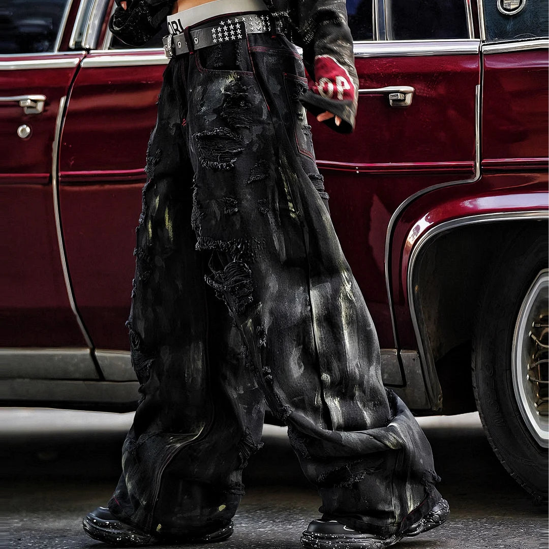 Sanhoostudio heavyweight denim pants featuring embroidery, graffiti details, and washed distressed texture. Designed with patchwork construction for bold unisex streetwear styling.