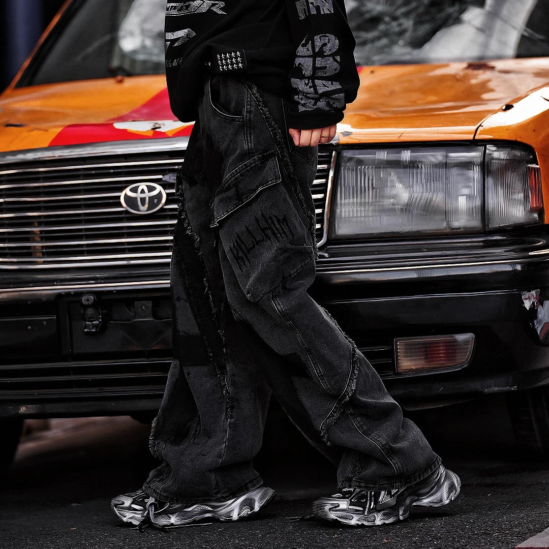 Sanhoostudio heavyweight denim featuring embroidery, graffiti artwork, and washed distressed finish. Designed with patchwork construction for bold unisex streetwear styling.