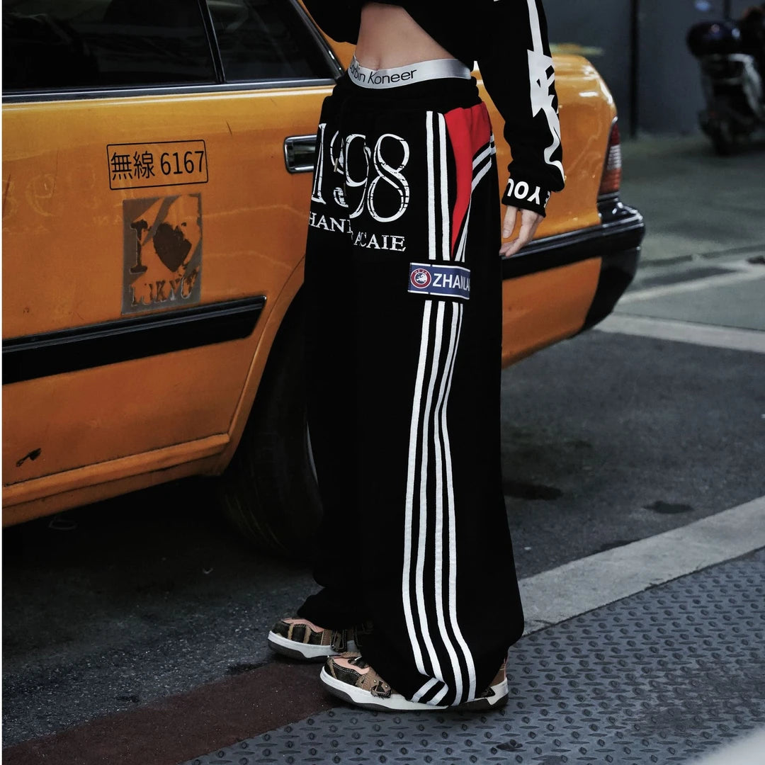 Sanhoostudio heavyweight sweatpants featuring fleece lining and printed details. Designed for unisex comfort and warm streetwear styling in fall and winter.