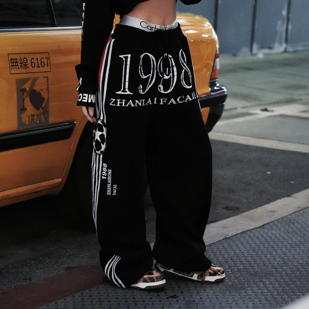Sanhoostudio heavyweight sweatpants featuring fleece lining and printed details. Designed for unisex comfort and warm streetwear styling in fall and winter.