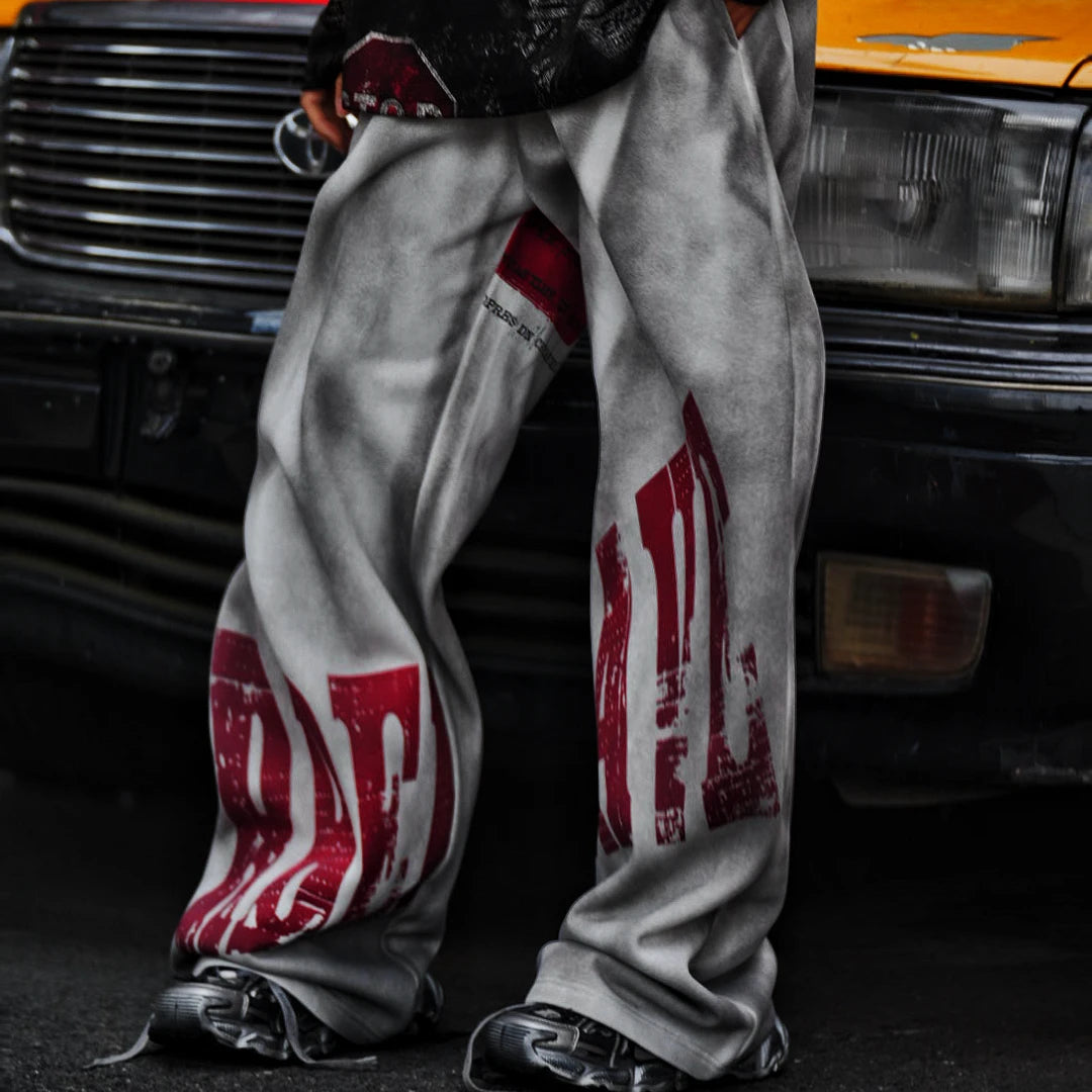 Sanhoostudio sweatpants featuring distressed letter graphics and fleece lining for warmth. Designed with an oversized wide leg fit for unisex vintage-inspired streetwear styling.