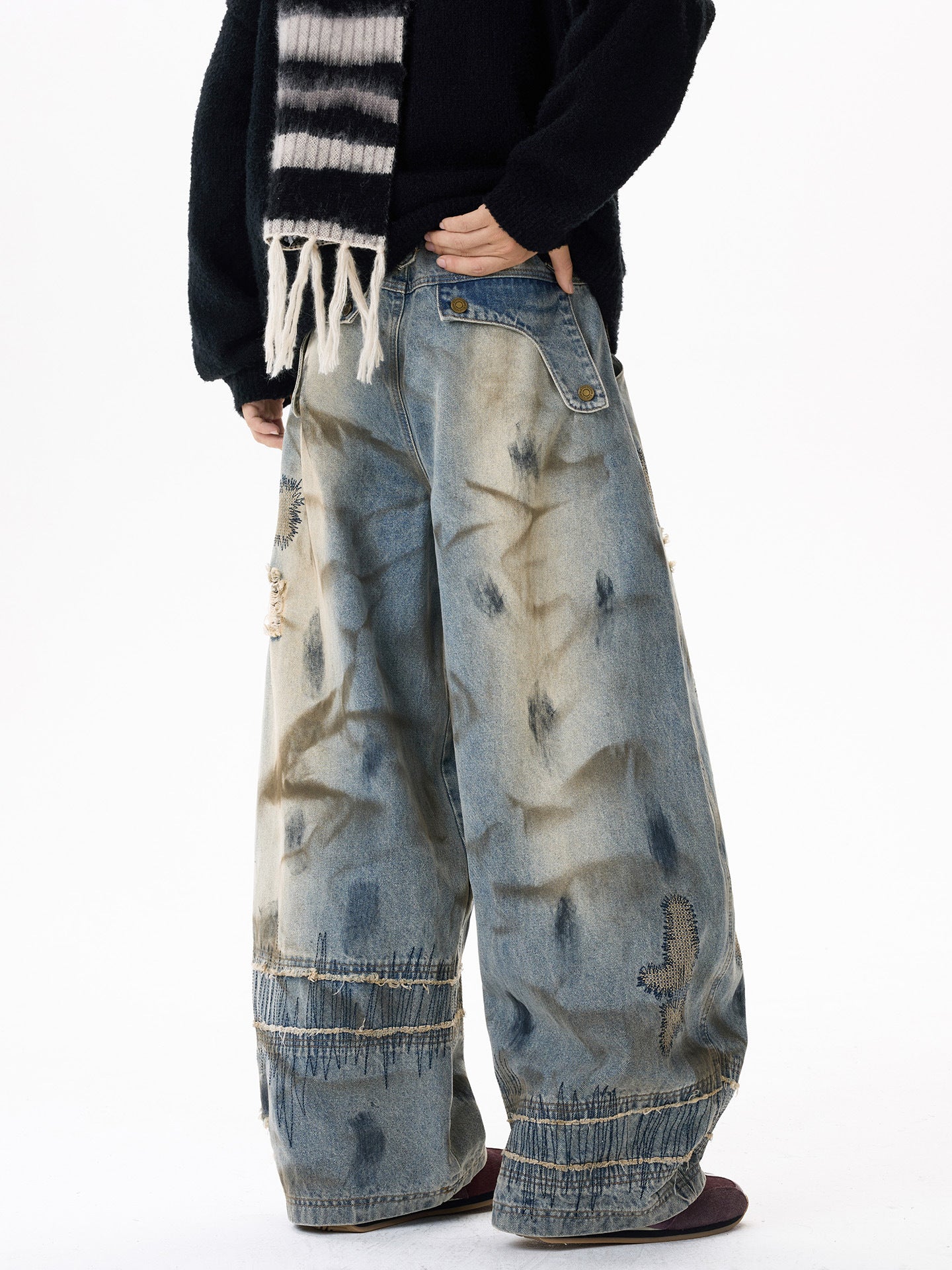 Sanhoostudio wide leg denim pants featuring distressed wash, heavy embroidery, and wasteland-inspired design. Built with a loose fit silhouette for bold streetwear styling.