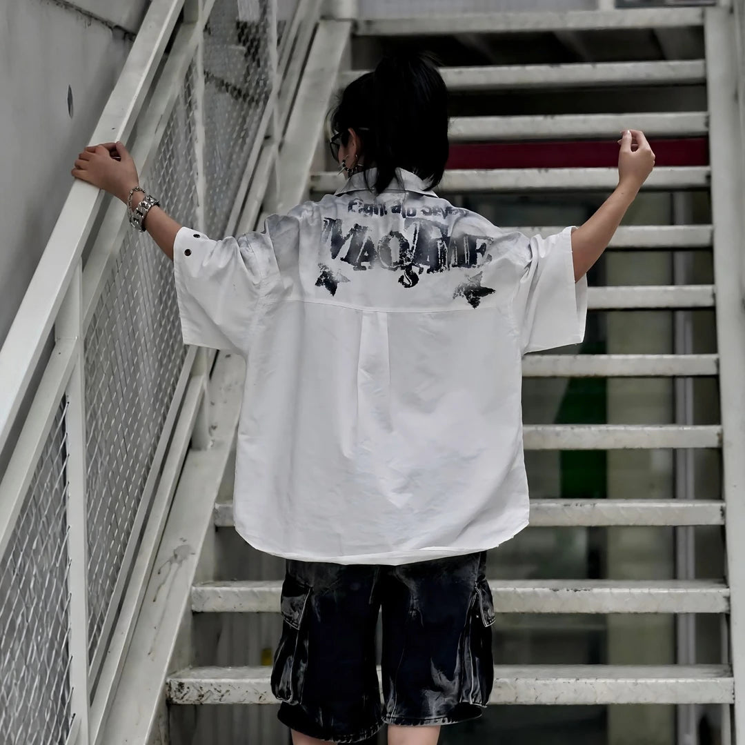 Sanhoostudio short sleeve shirt featuring graffiti print, distressed finish, and relaxed fit silhouette. Designed for modern streetwear styling with breathable fabric and versatile everyday wear.