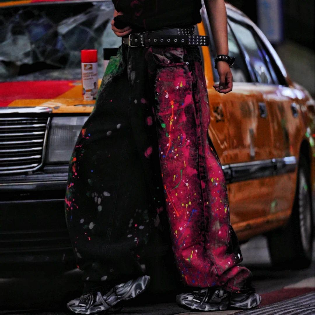 Sanhoostudio denim pants featuring graffiti artwork, patchwork construction, and distressed wash finish. Designed with a wide leg silhouette for bold streetwear styling with durability and comfort.
