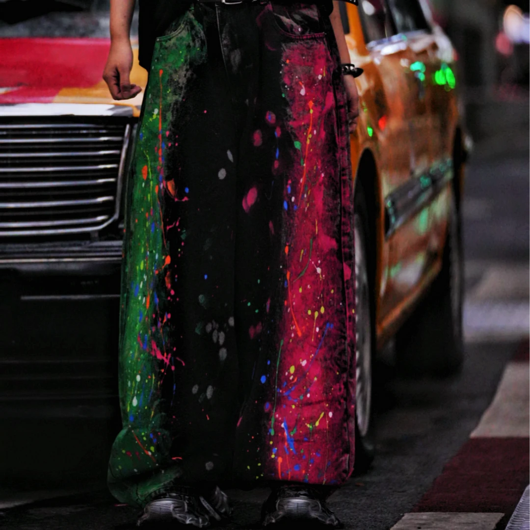 Sanhoostudio denim pants featuring graffiti artwork, patchwork construction, and distressed wash finish. Designed with a wide leg silhouette for bold streetwear styling with durability and comfort.