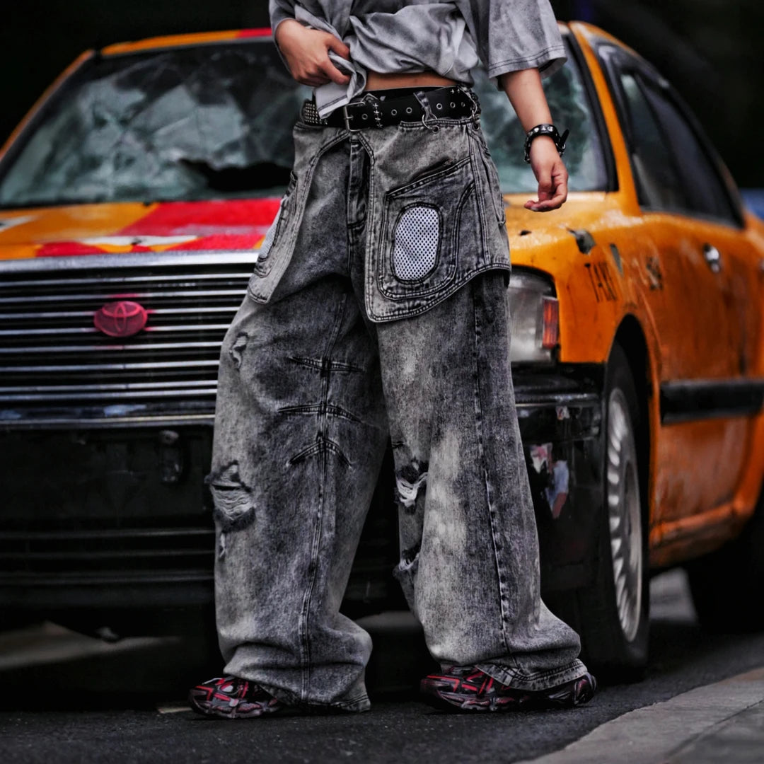 Sanhoostudio denim pants featuring layered patchwork construction, distressed wash finish, and detachable styling elements. Designed for bold streetwear outfits with relaxed comfort and unique visual structure.