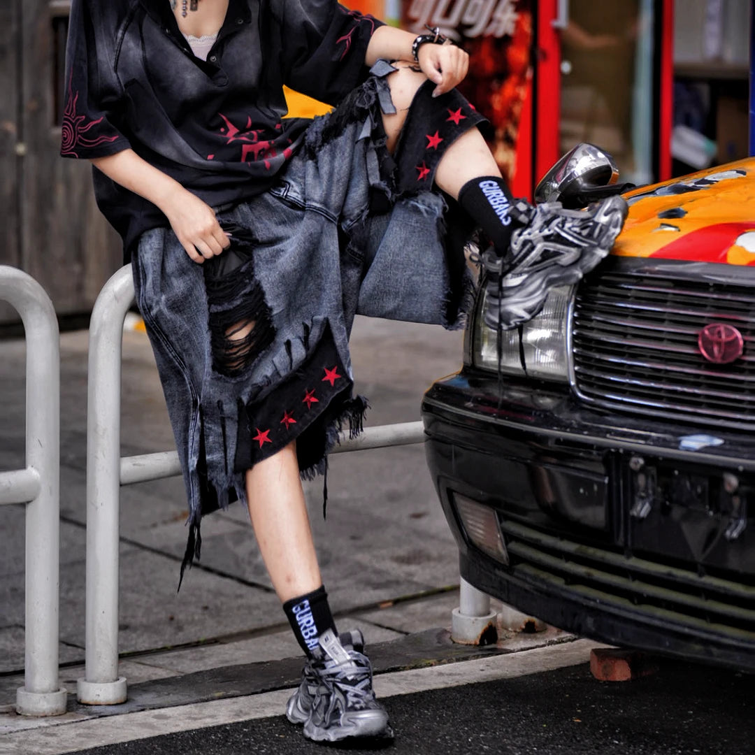Sanhoostudio denim shorts featuring distressed wash finish, graffiti detailing, and patchwork construction with a relaxed loose fit. Built for summer streetwear outfits with breathable comfort and standout urban styling.