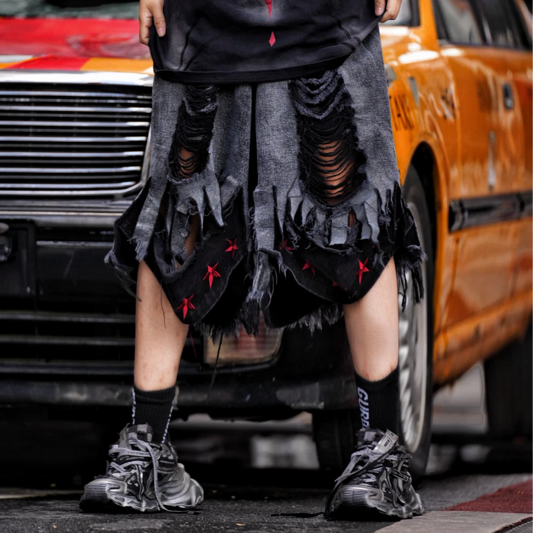 Sanhoostudio denim shorts featuring distressed wash finish, graffiti detailing, and patchwork construction with a relaxed loose fit. Built for summer streetwear outfits with breathable comfort and standout urban styling.